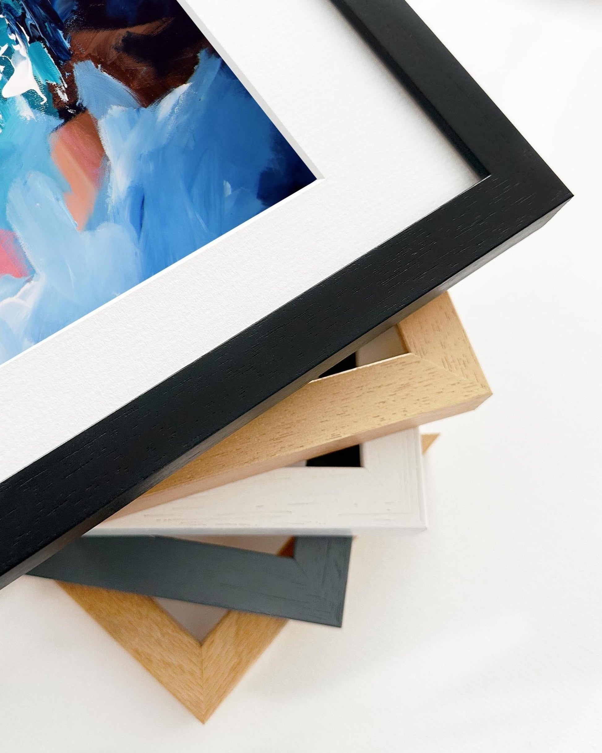 Stack of variously colored picture frames on a white background