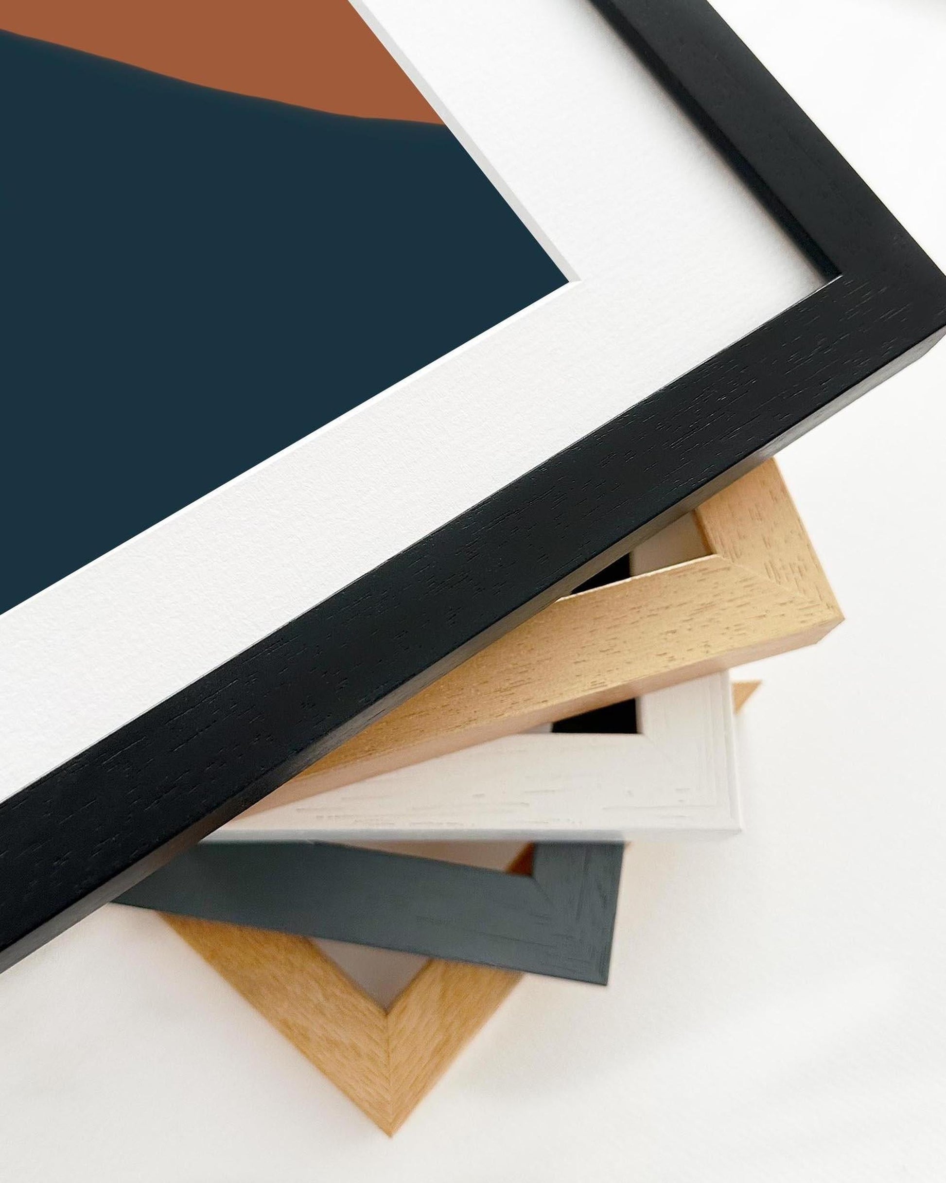 Stack of various wooden picture frames on a white background