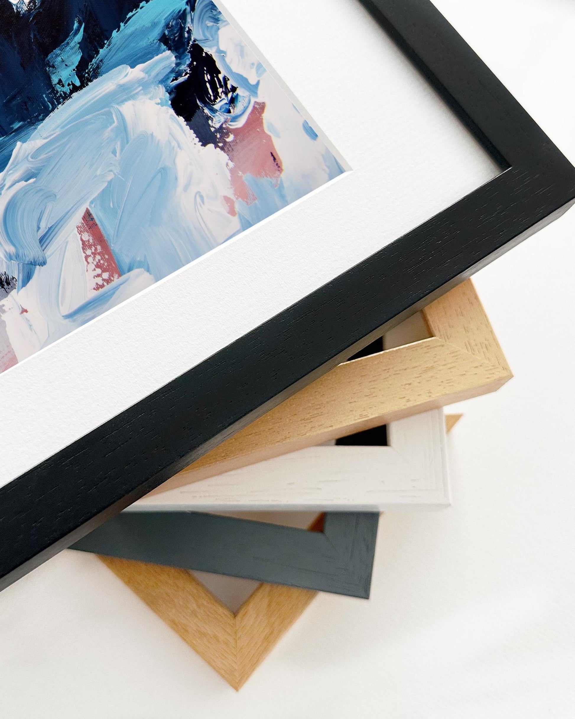 Stack of variously colored picture frames on a white surface