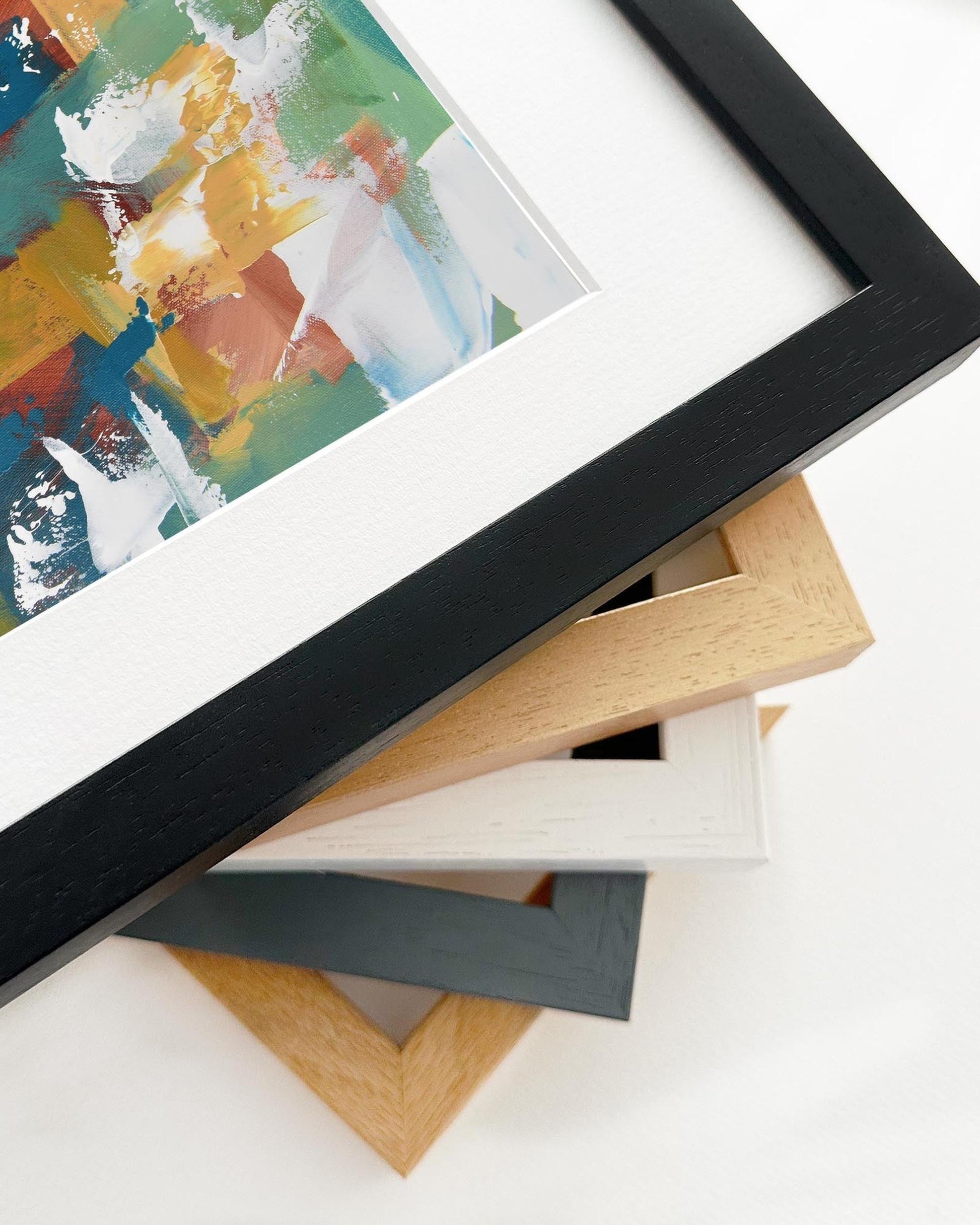 Stack of variously colored picture frames on a white surface
