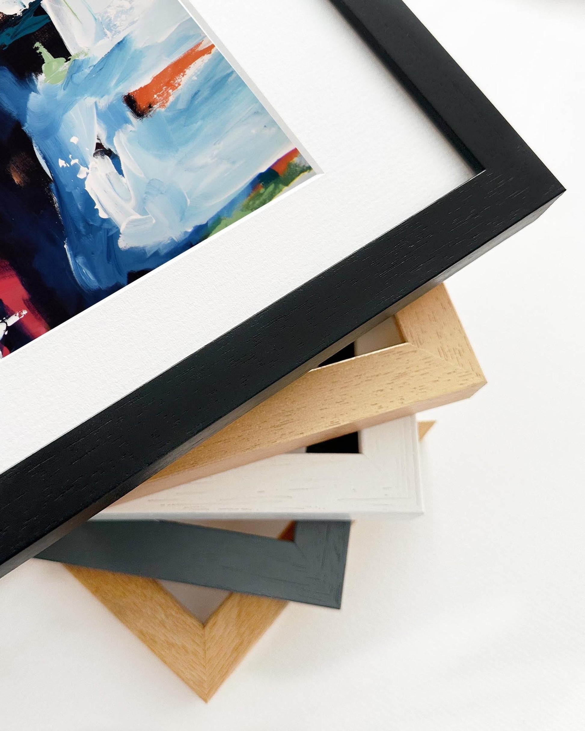Stack of variously colored picture frames on a white surface