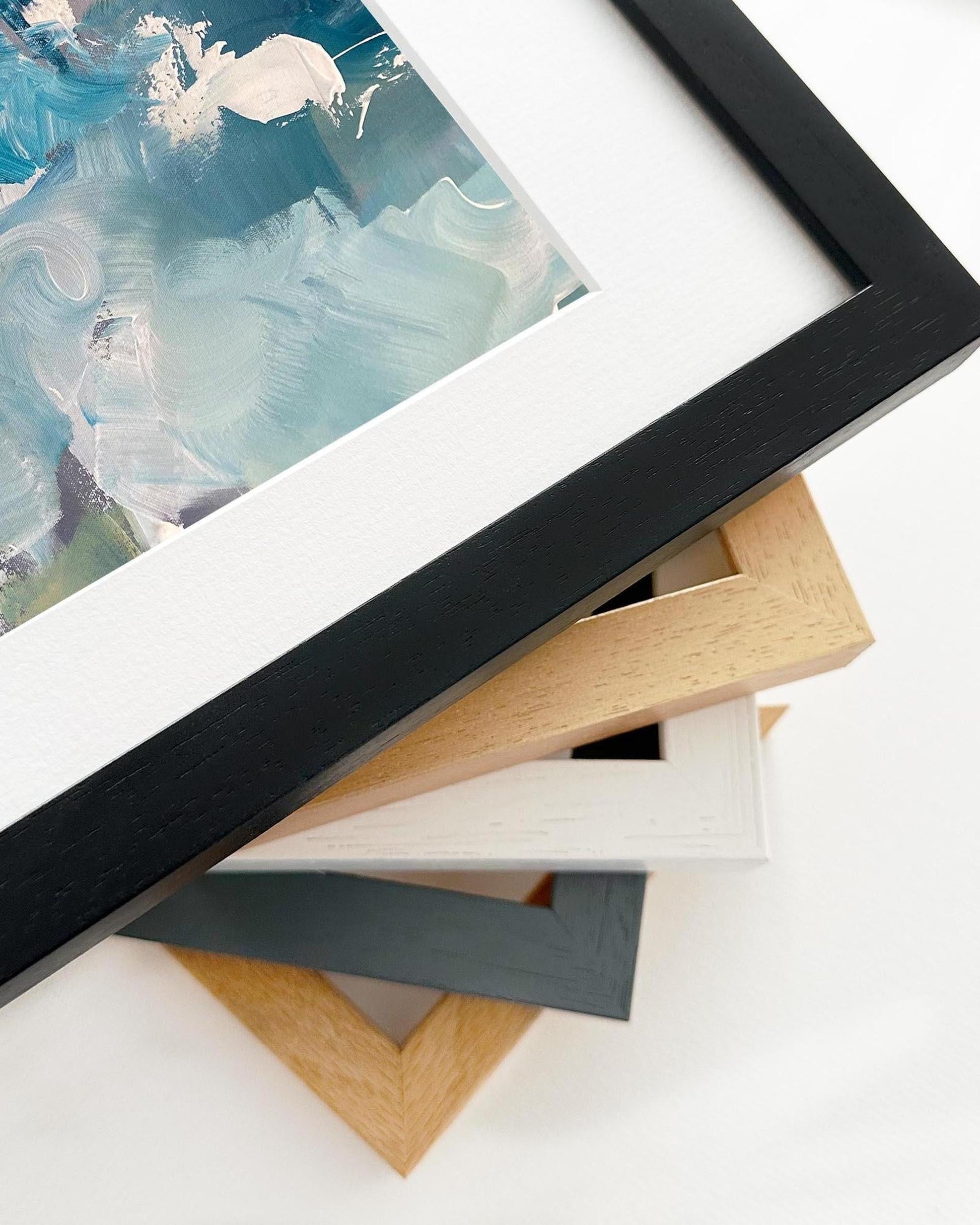 Collection of variously sized picture frames on a white surface