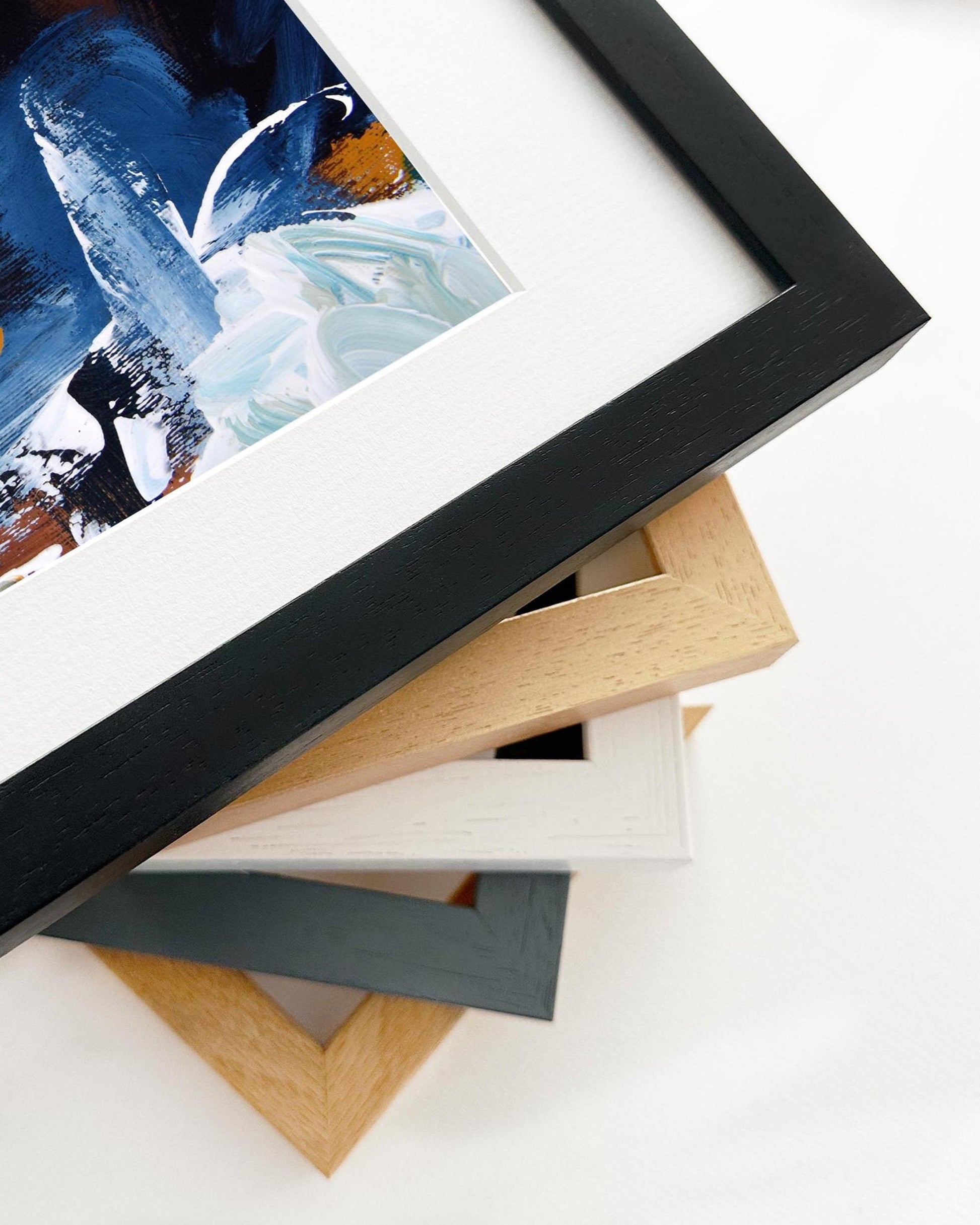 Stack of variously colored picture frames on a white surface