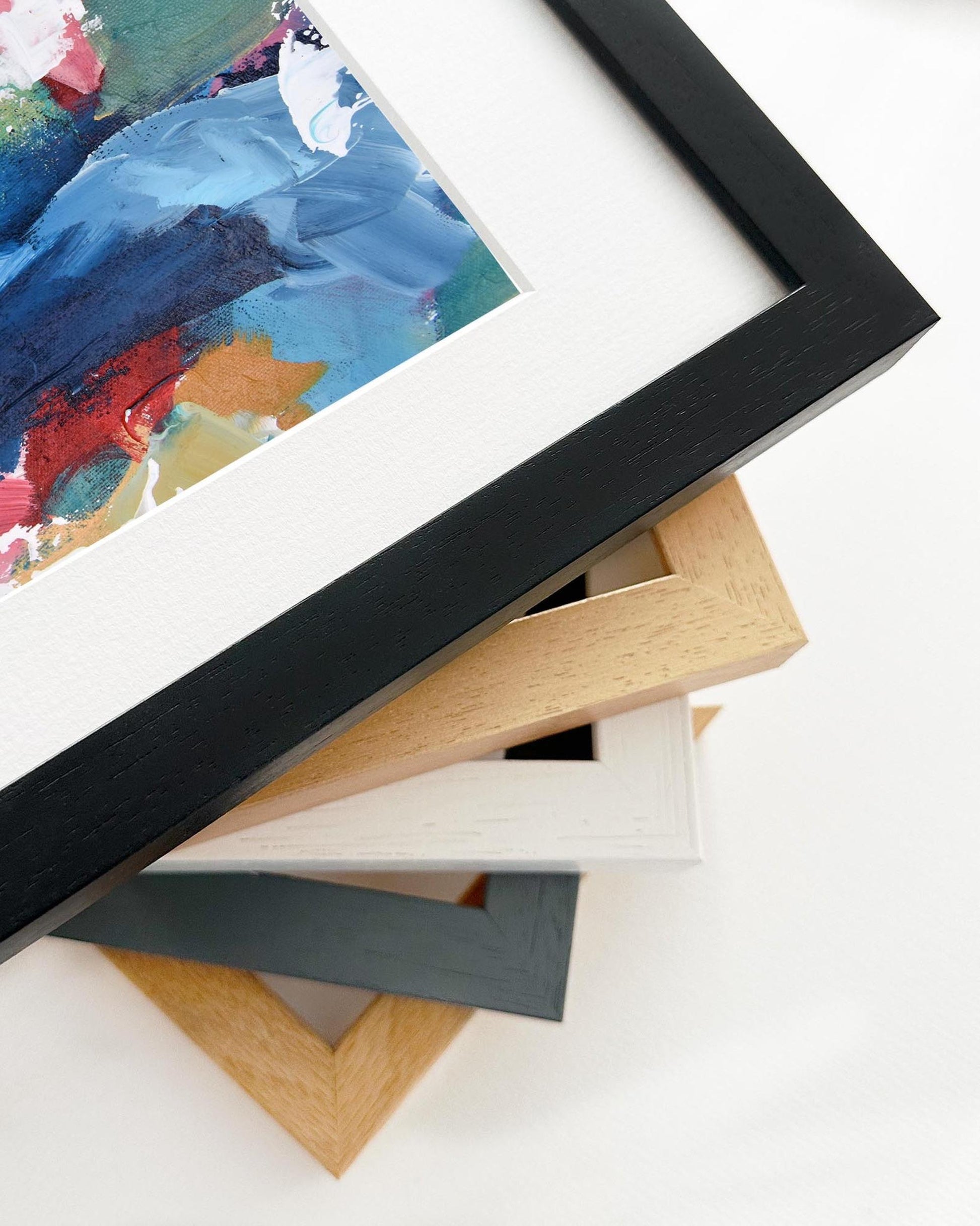 Stack of variously colored picture frames on a white surface