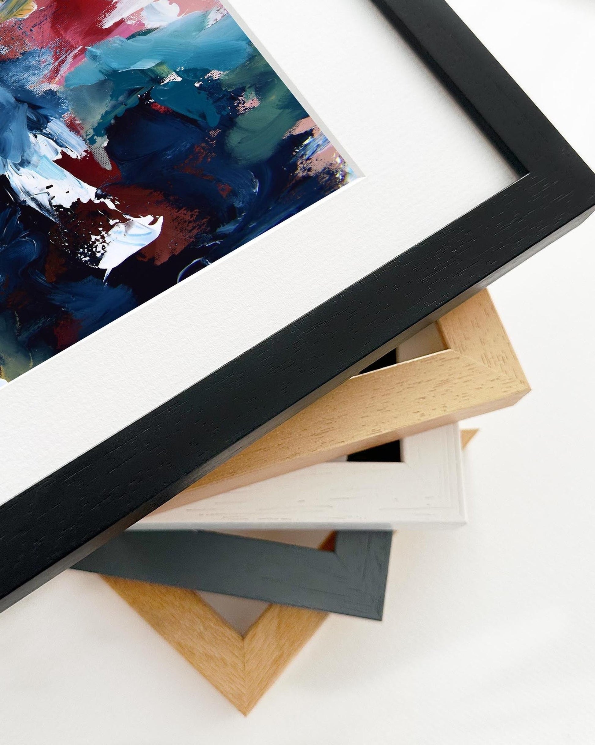 Framed abstract painting with various wooden frames on a white surface