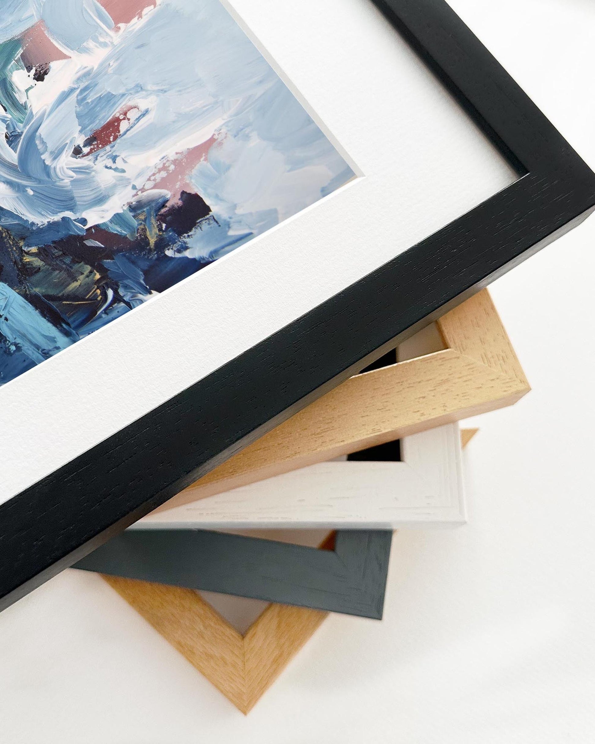 Framed artwork with a stack of variously colored frames on a white background