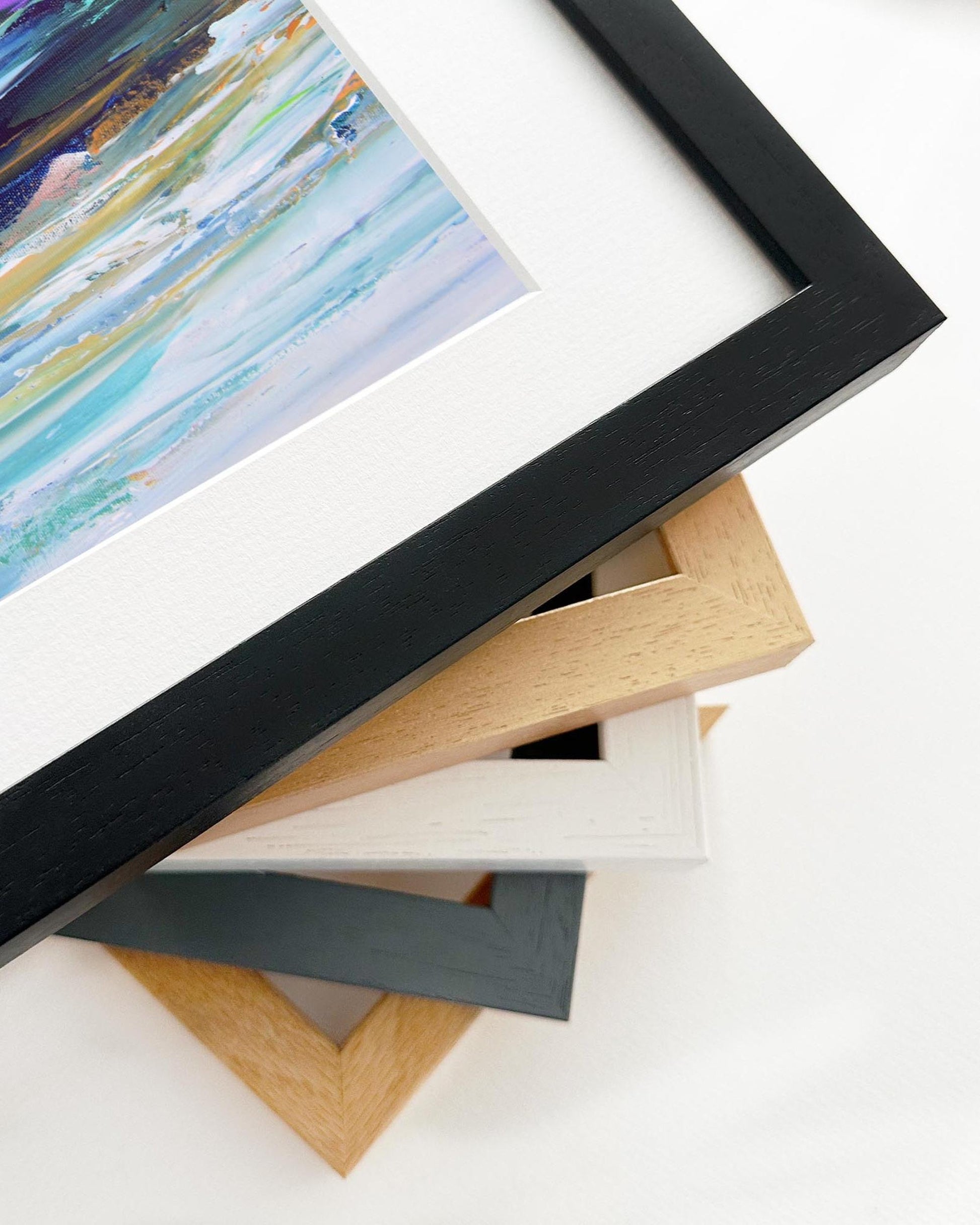 Stack of variously colored picture frames on a white surface