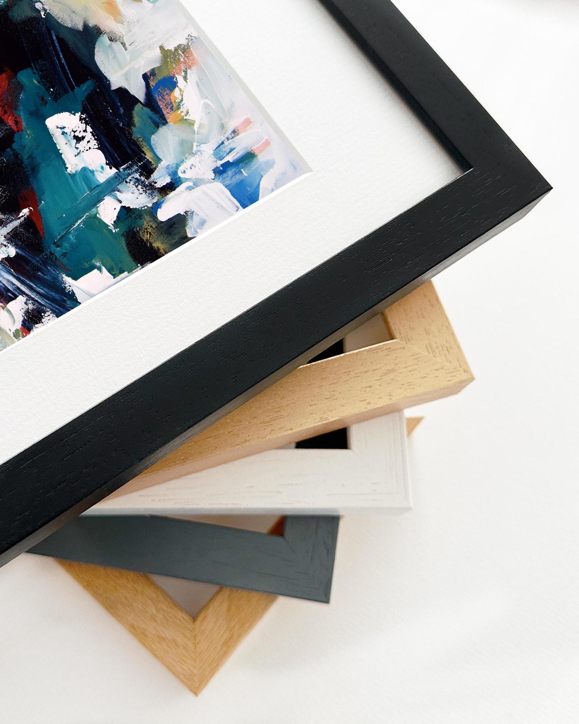 Stack of variously colored picture frames on a white surface