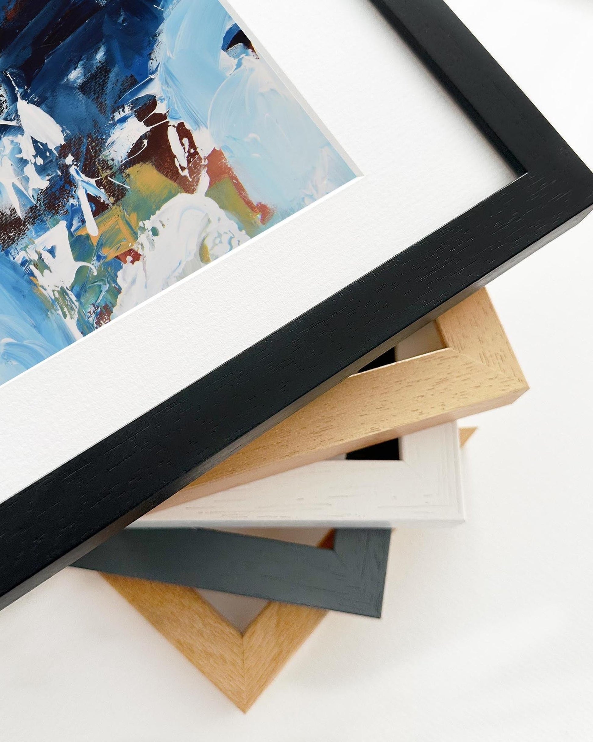 Stack of variously colored picture frames on a white surface