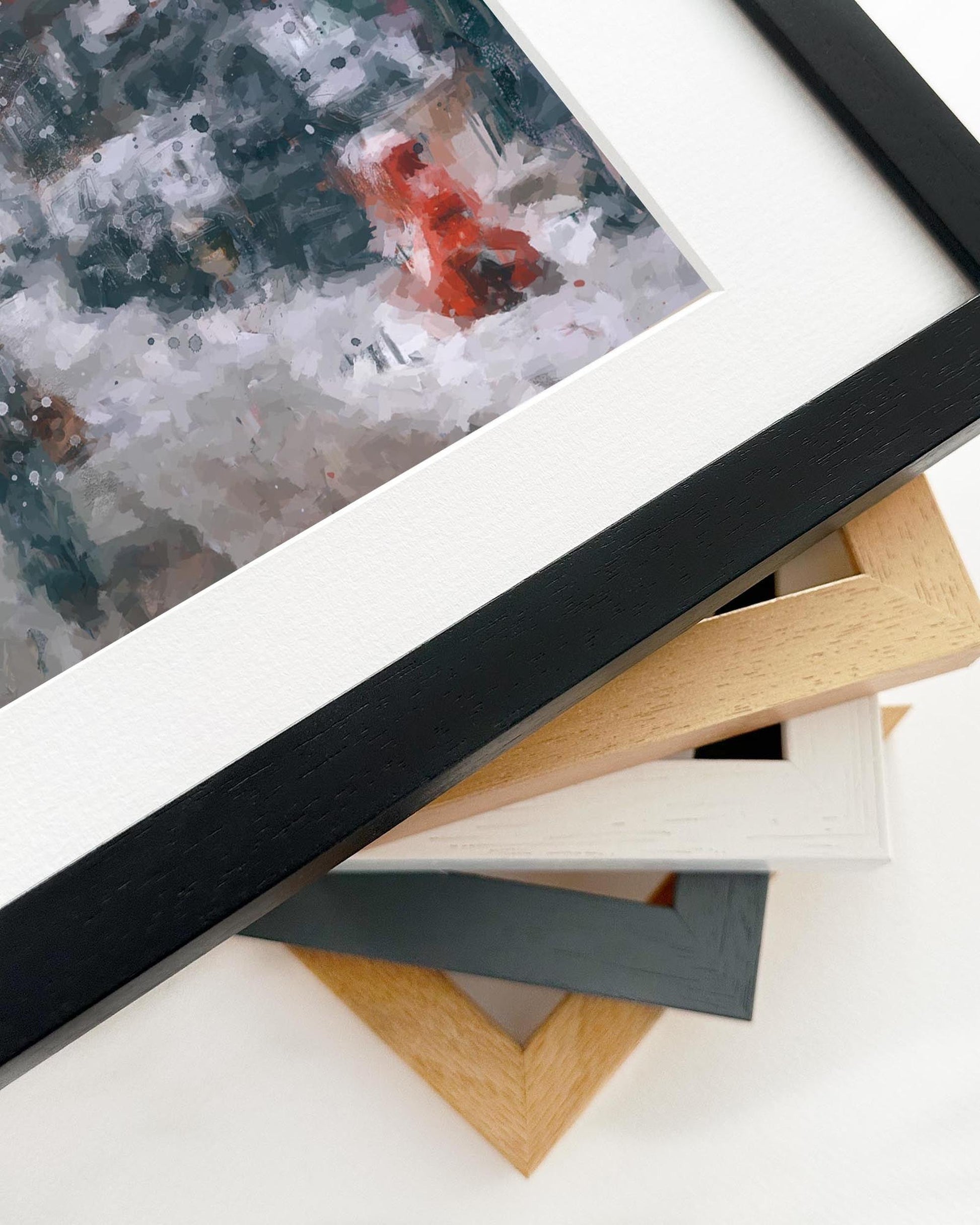 Stack of various wooden picture frames on a white surface