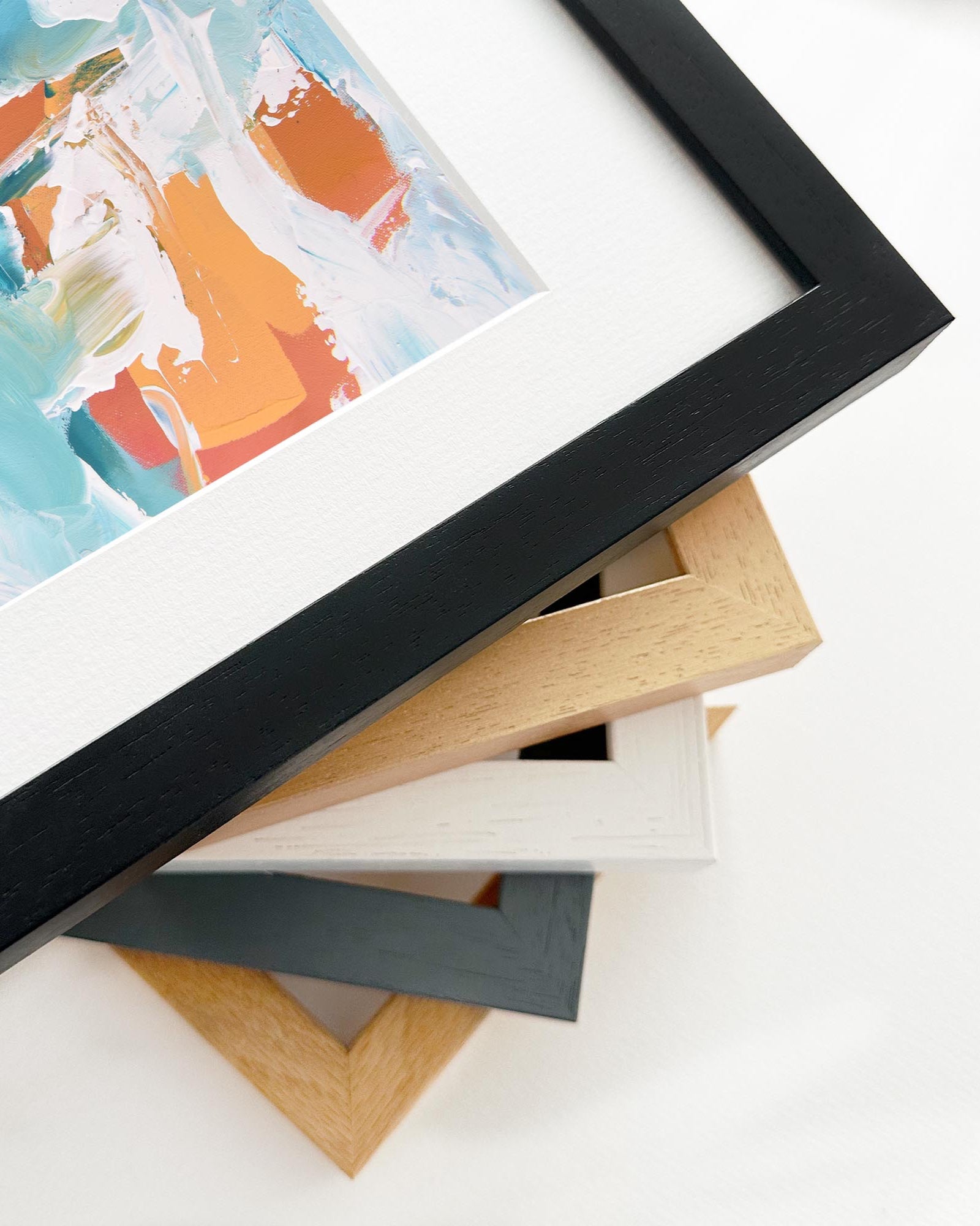 Stack of variously colored picture frames on a white surface