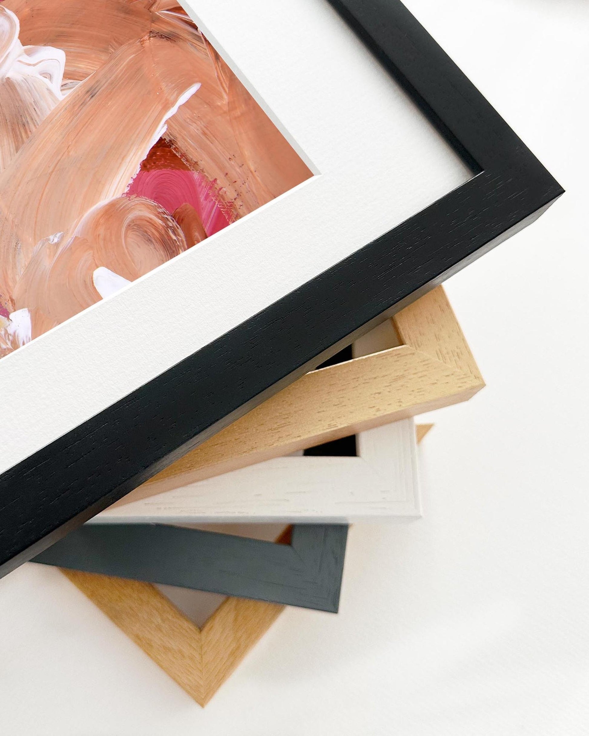 Stack of various wooden picture frames on a white background