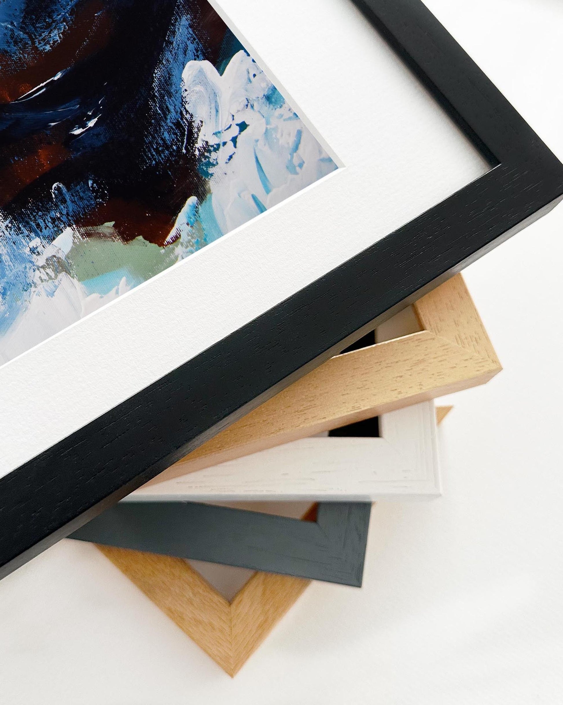 Stack of variously colored picture frames on a white surface