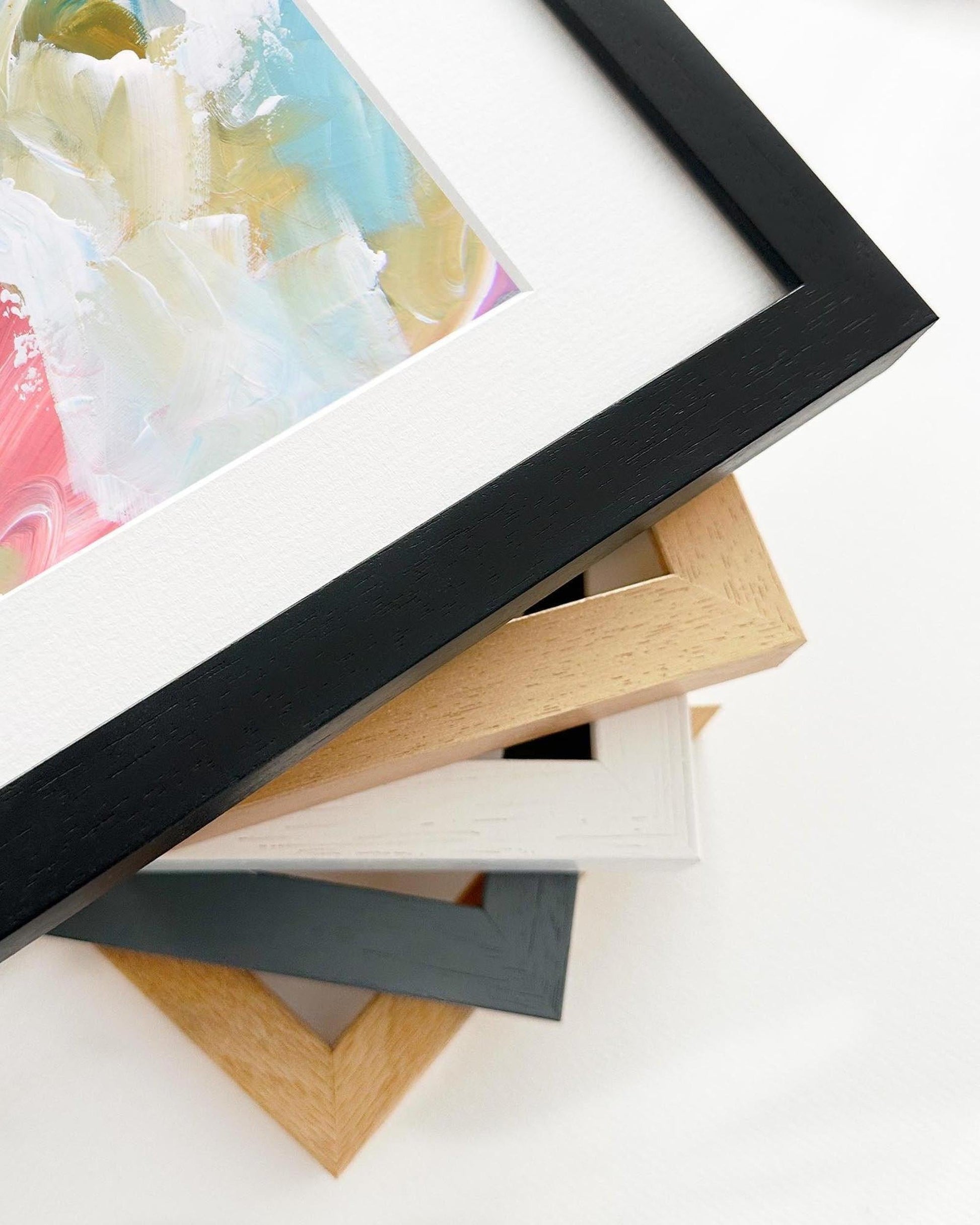 Stack of variously colored picture frames on a white surface