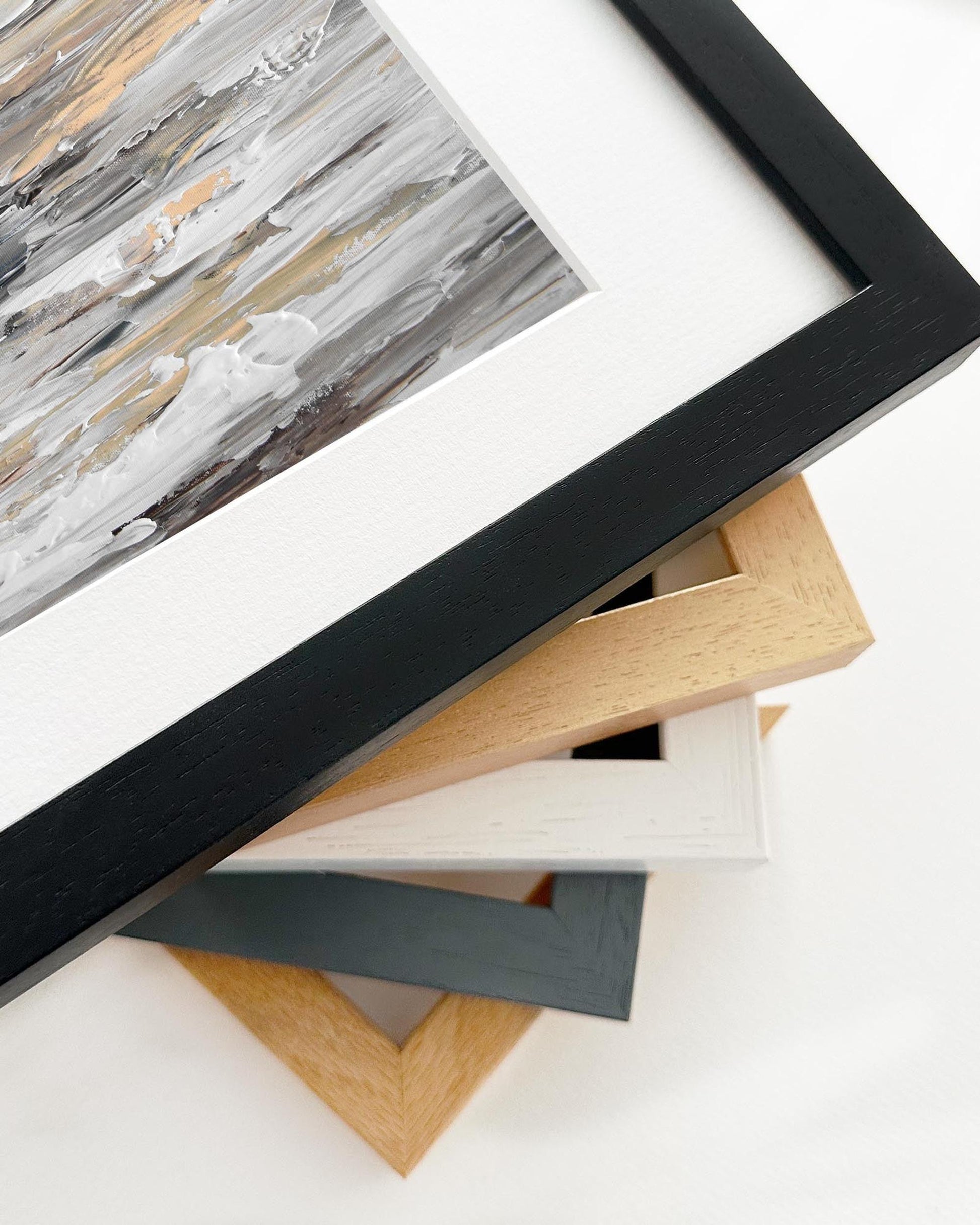 Stack of variously colored picture frames on a white surface