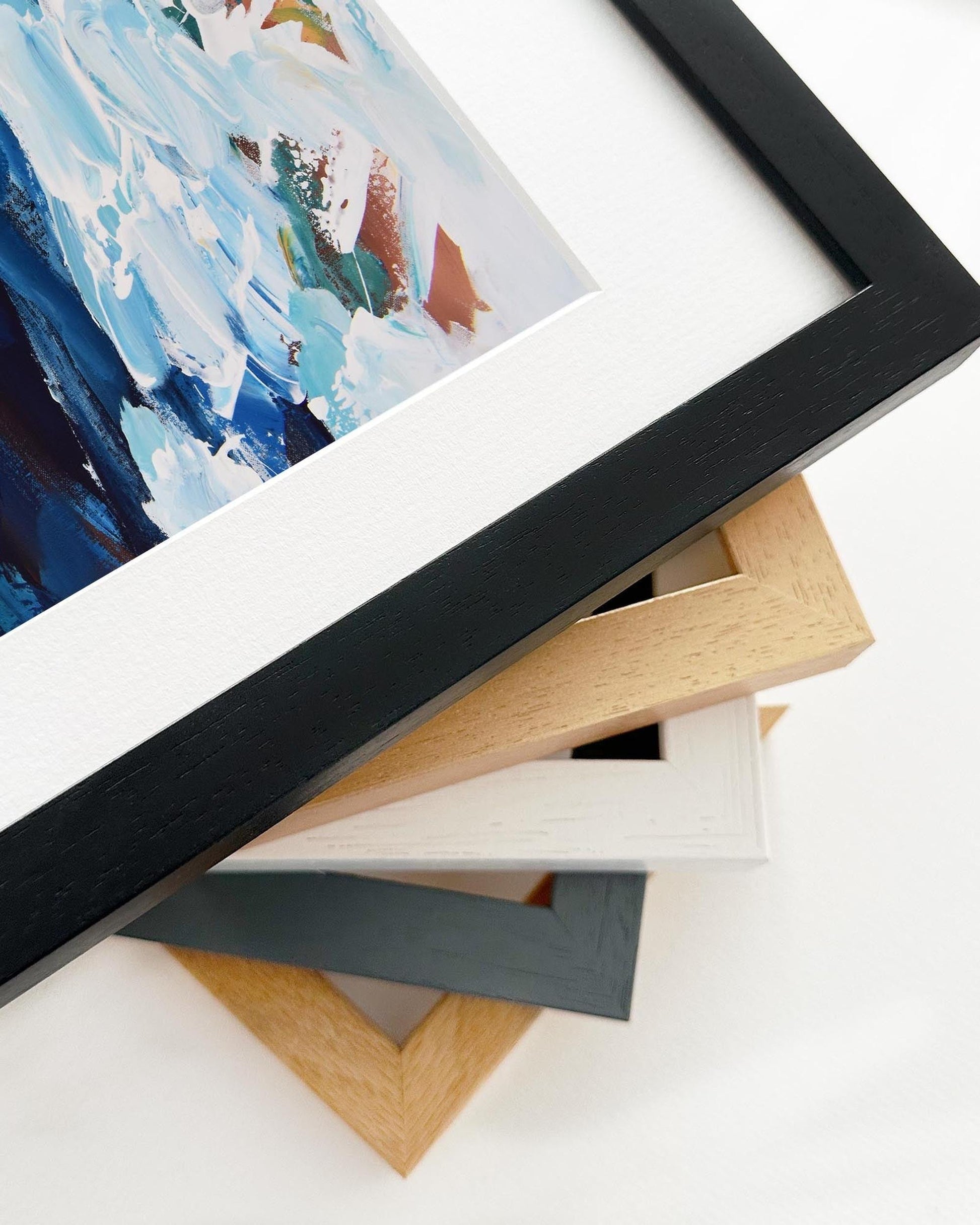 Stack of variously colored picture frames on a white surface