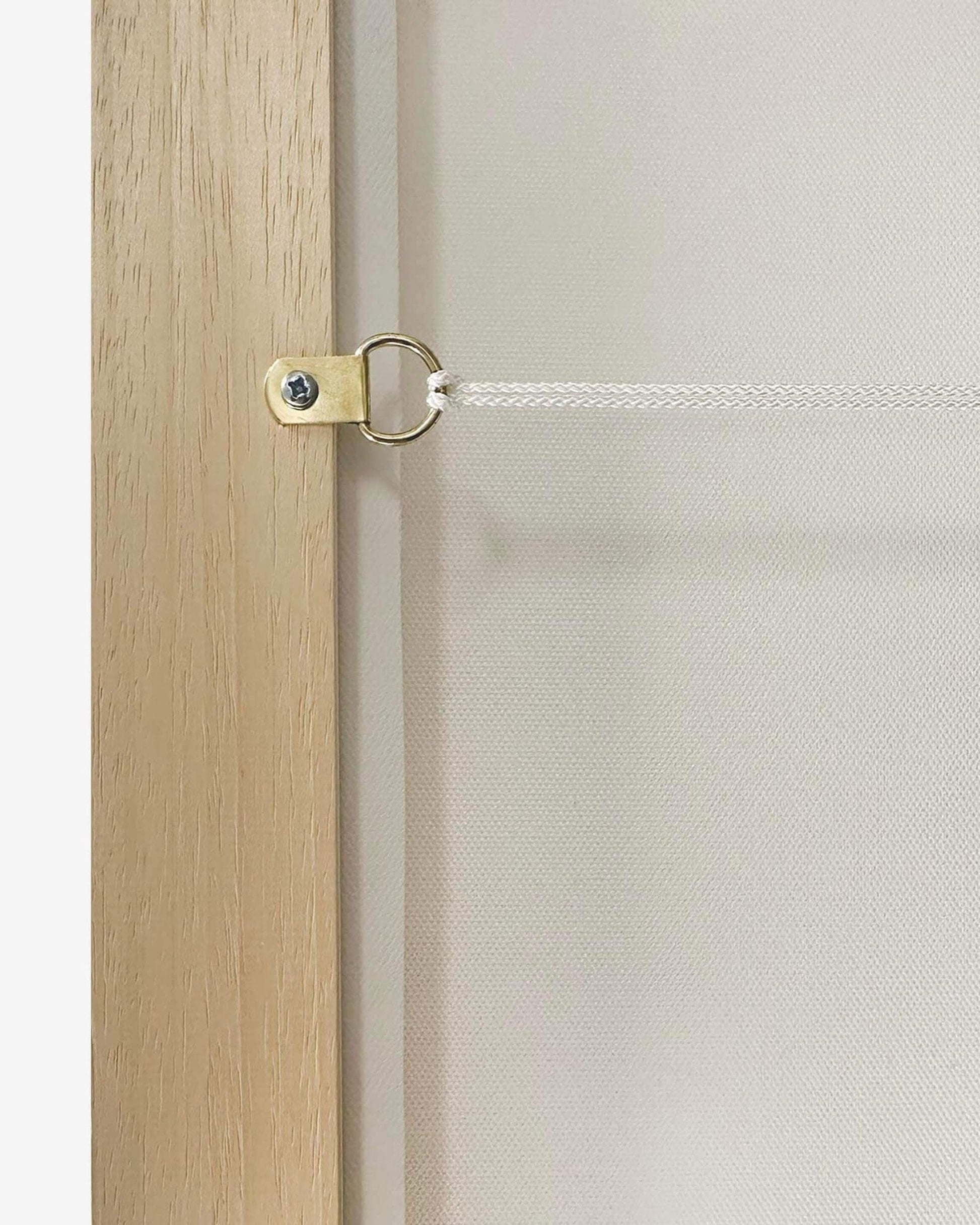 Close-up of a wooden door with a brass handle and white mesh screen.