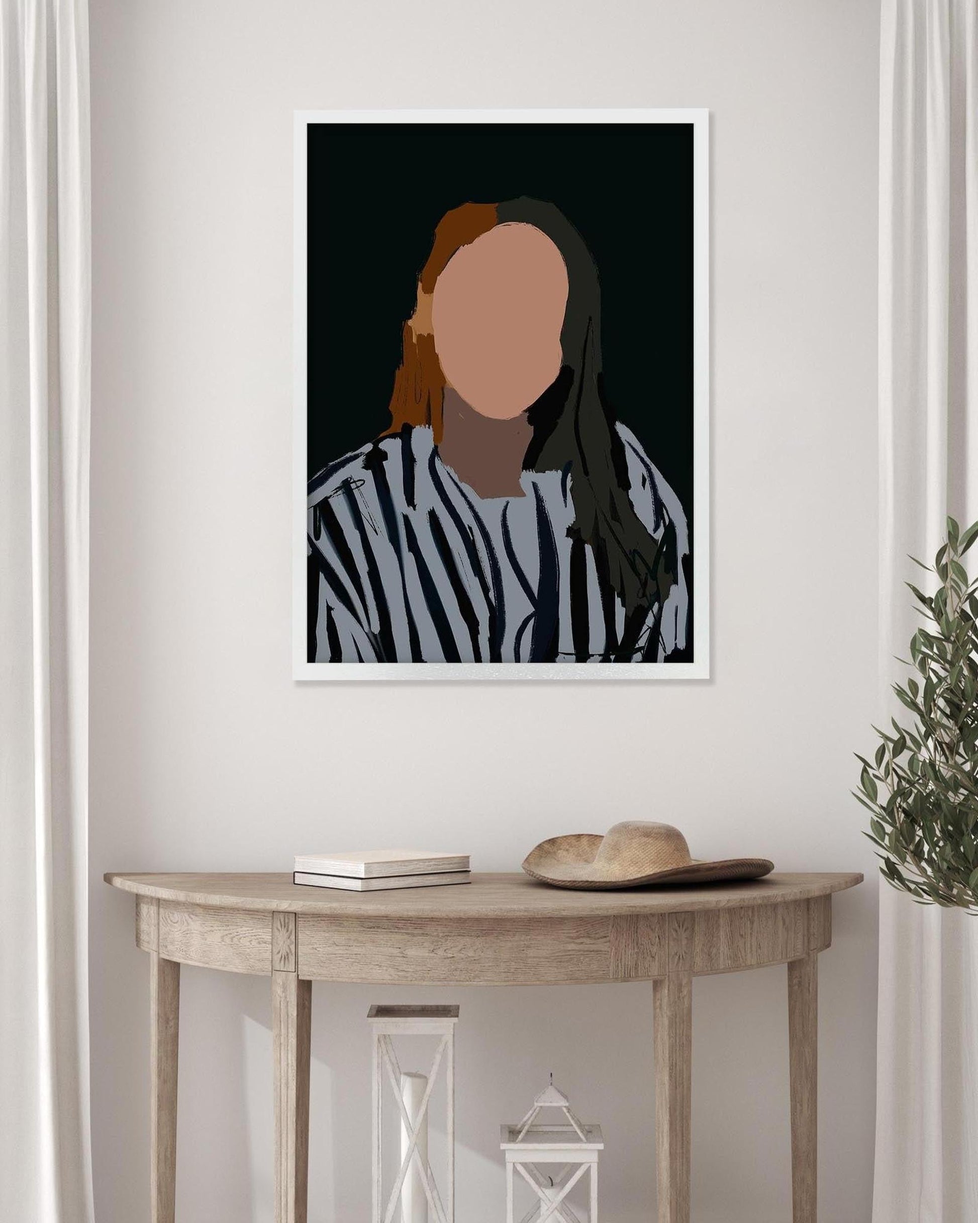 Framed portrait of a person with a blurred face on a wall above a wooden table.