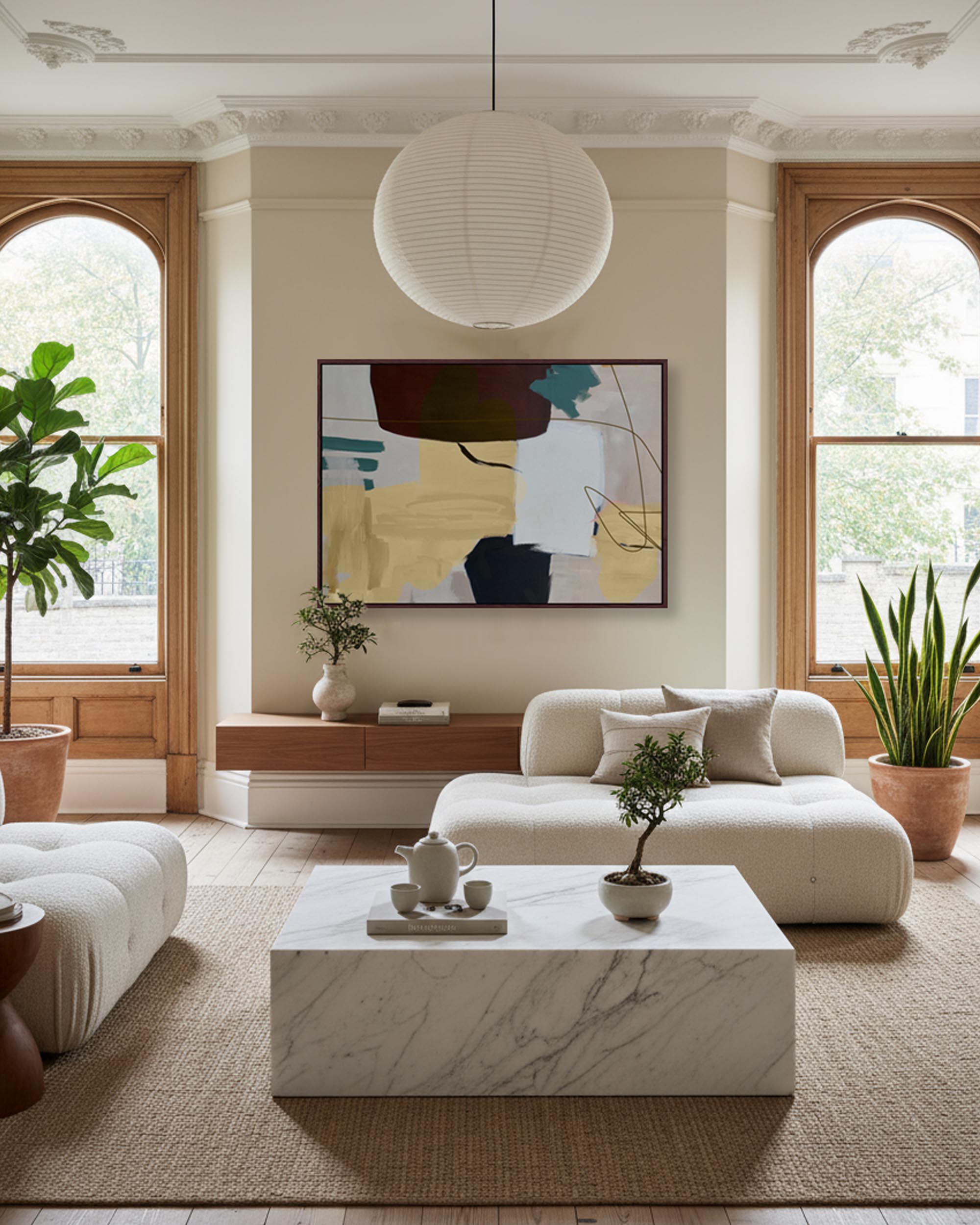 Modern living room with a white sofa, marble coffee table, and abstract art on the wall.