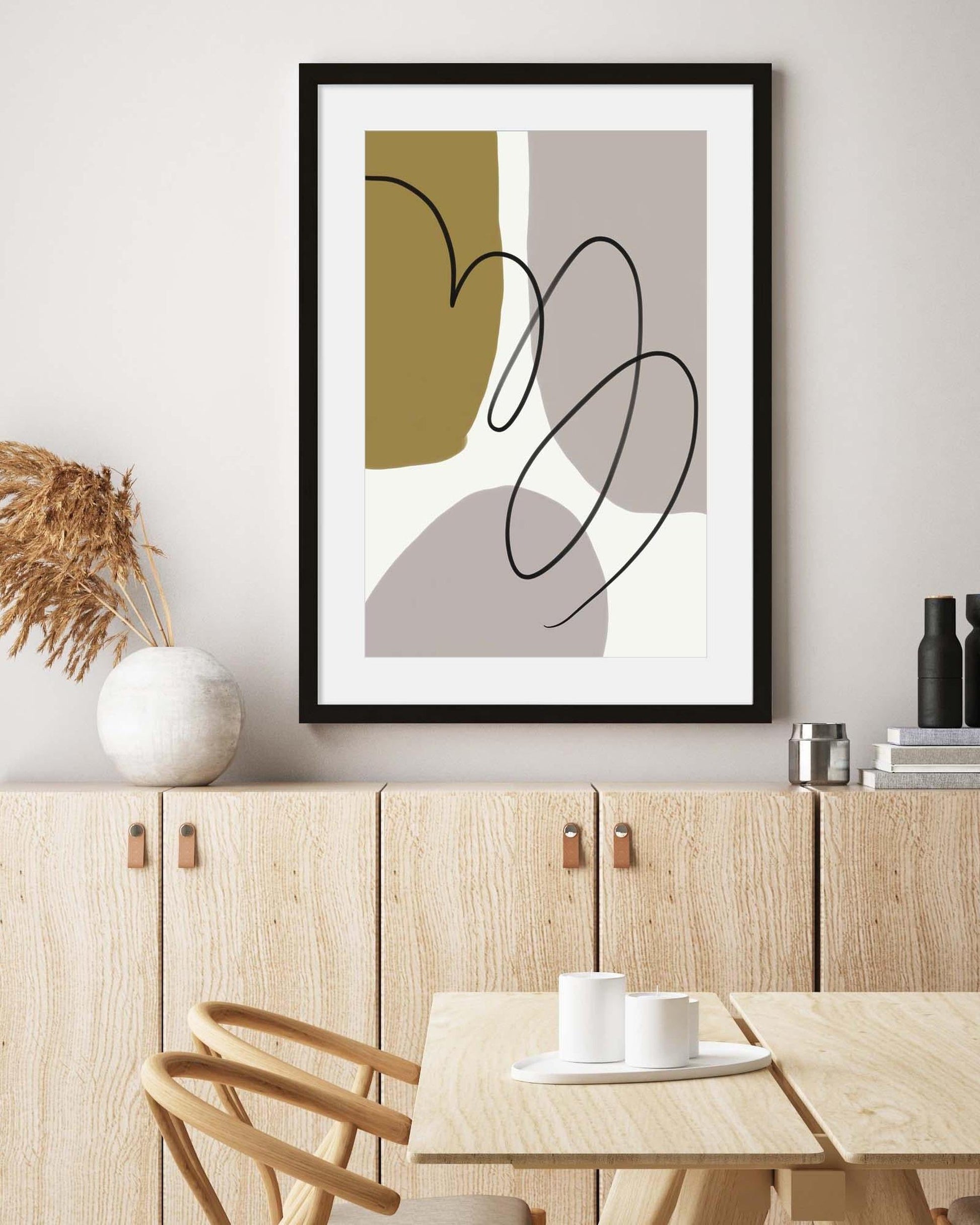 Abstract art print on a wall above a wooden dining area