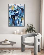 Modern living room with abstract art, gray chair, and decorative items.