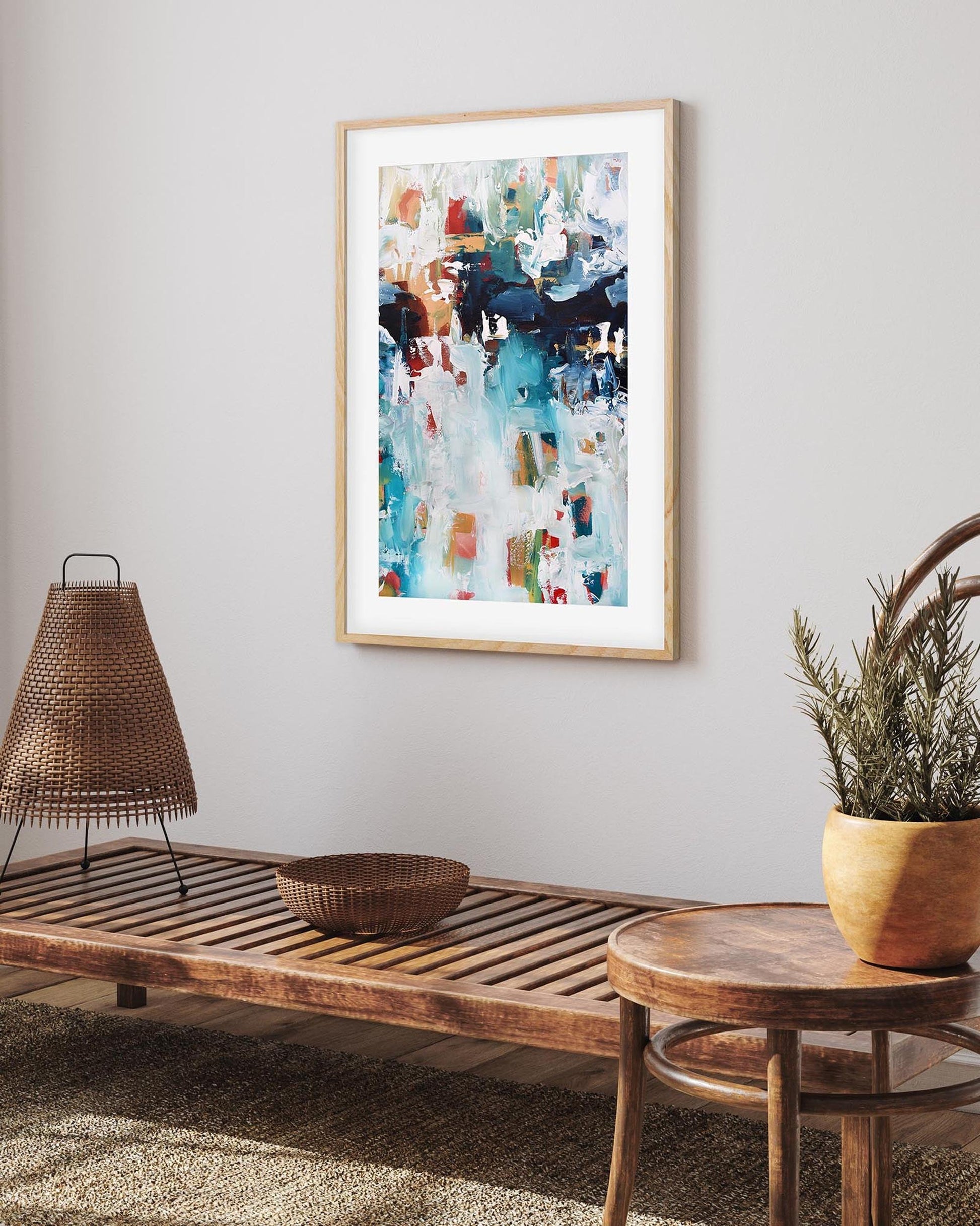 Living room with wooden bench, round table, and abstract art on the wall.