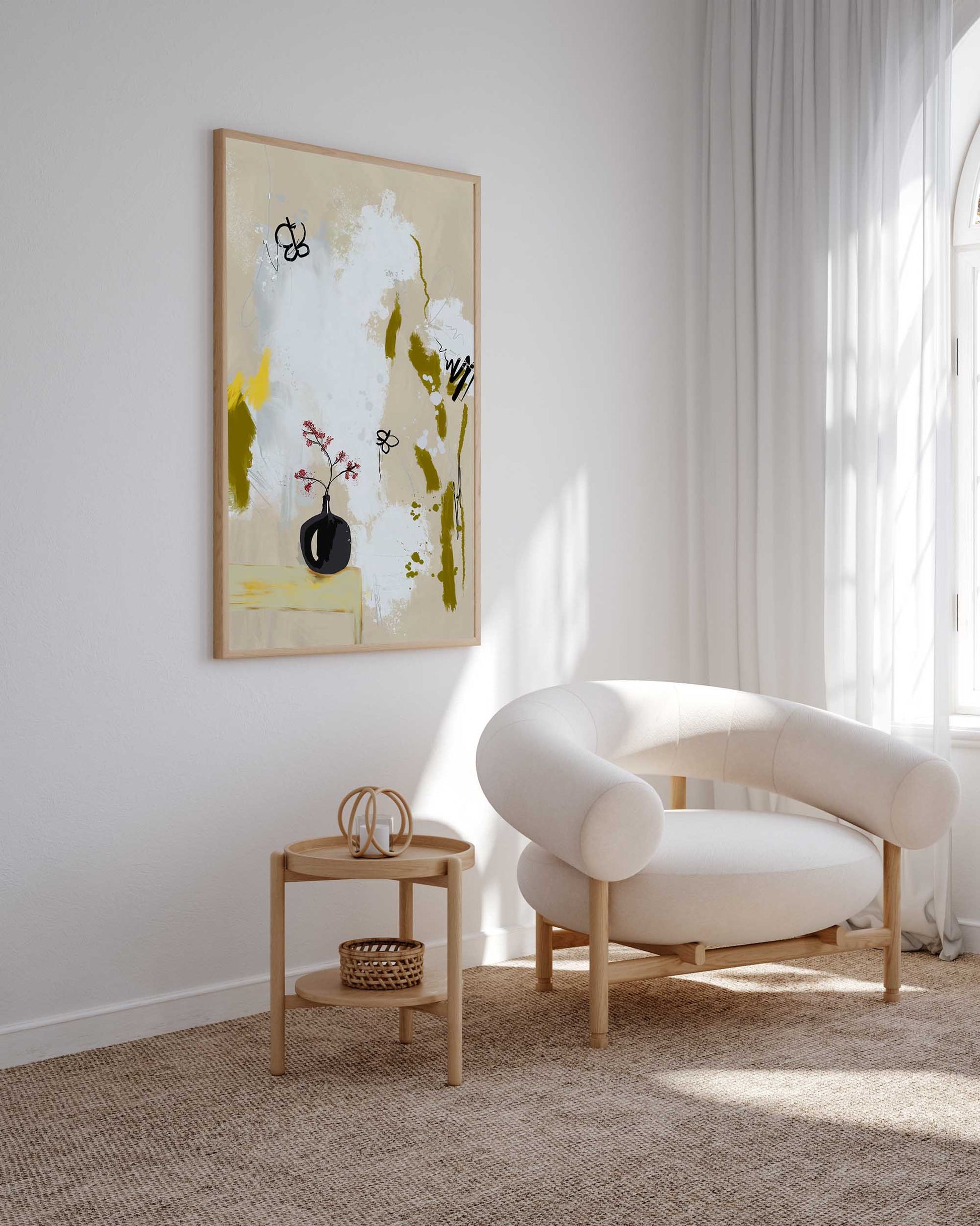 A contemporary abstract painting of flowers in a neutral color palette, displayed above a modern armchair in a bright room with a large window.