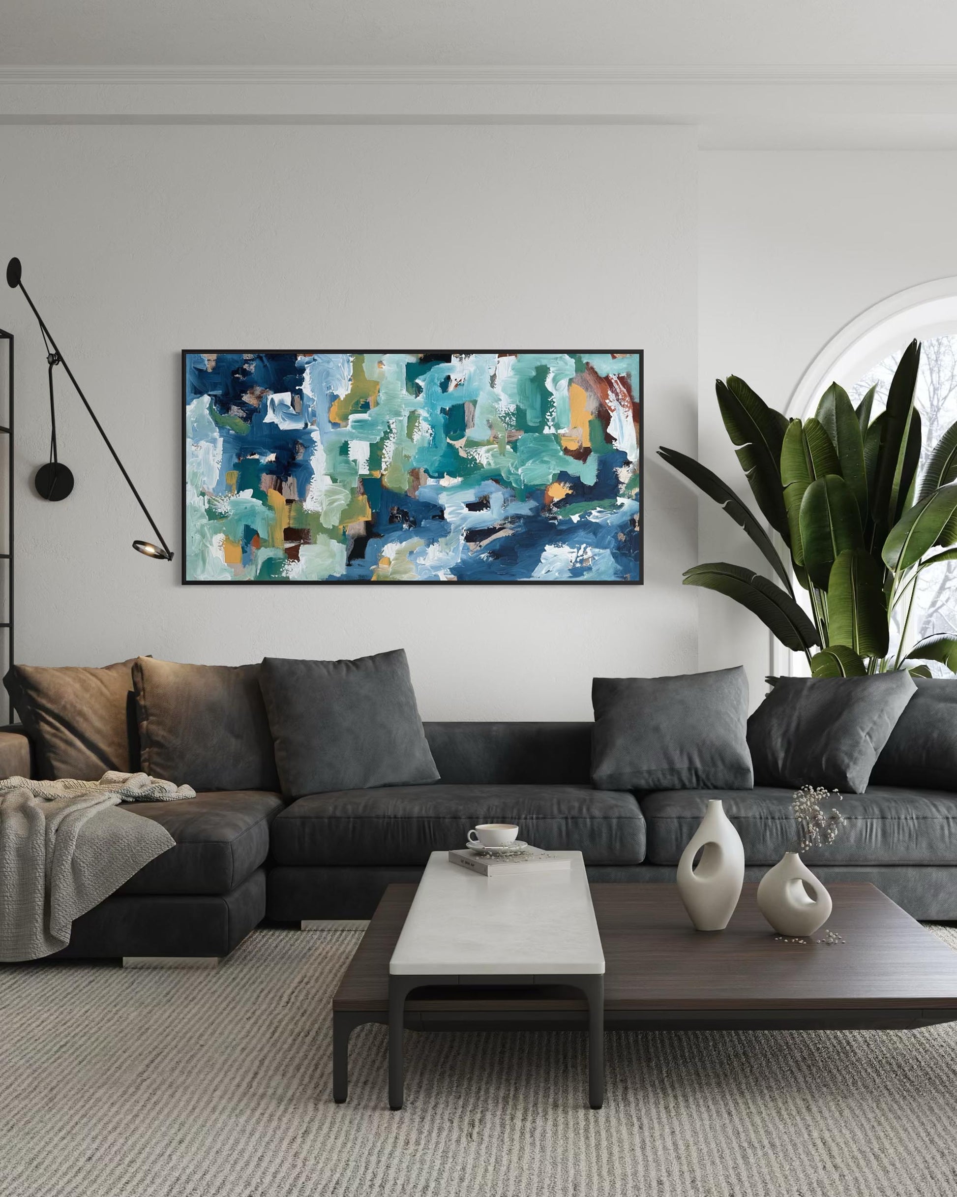 Modern living room with a gray sectional sofa, abstract painting, and decorative items.