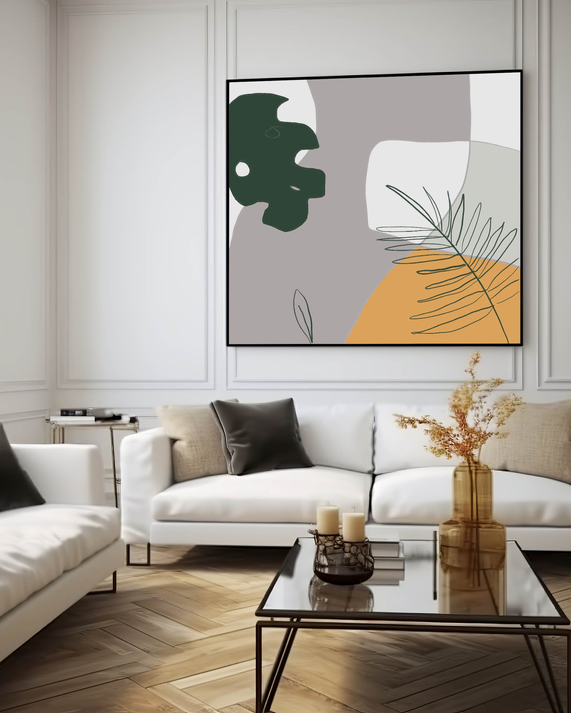 A framed canvas art print featuring abstract botanical elements with geometric shapes in yellow, white, grey, and green, displayed above a white sofa in a room with minimal decor.