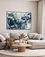 Living room with a gray sectional sofa, wooden coffee table, and abstract painting on the wall.