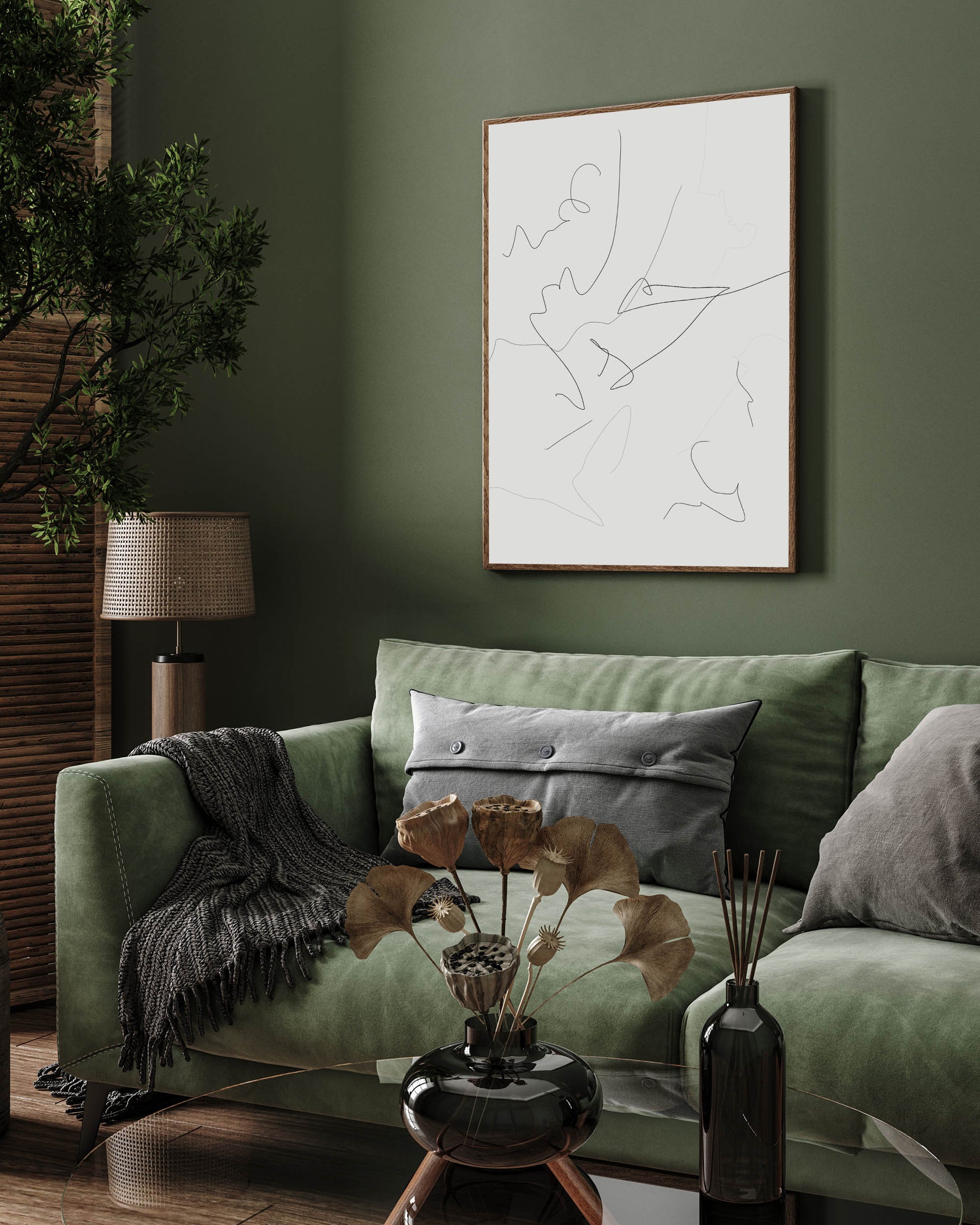 A framed canvas abstract line art hanging on a green wall above a green sofa with decorative pillows, next to a wooden lamp with a white shade.