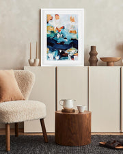 Modern interior with a textured chair, wooden side table, and abstract art on a wall.