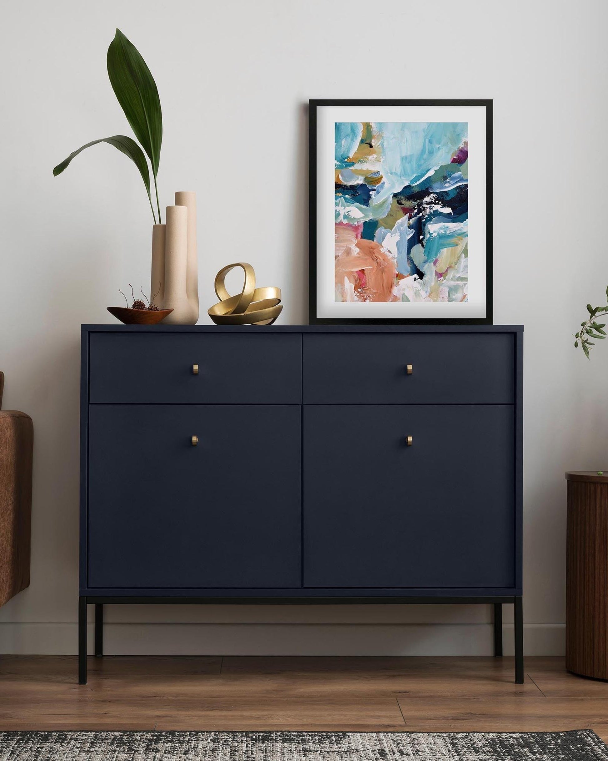 Navy blue dresser with decorative items in a room setting