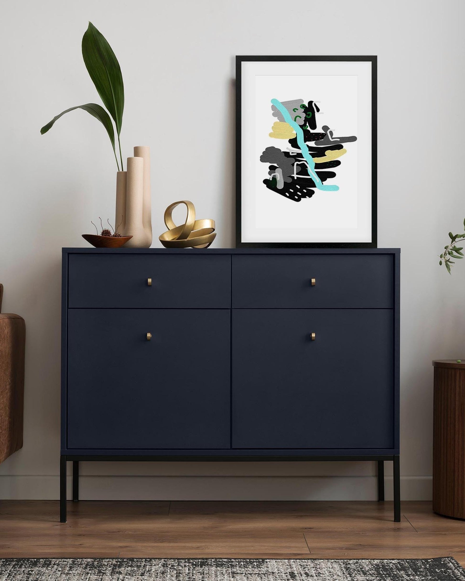 Navy blue sideboard with decorative items and a framed abstract art print on a white wall.
