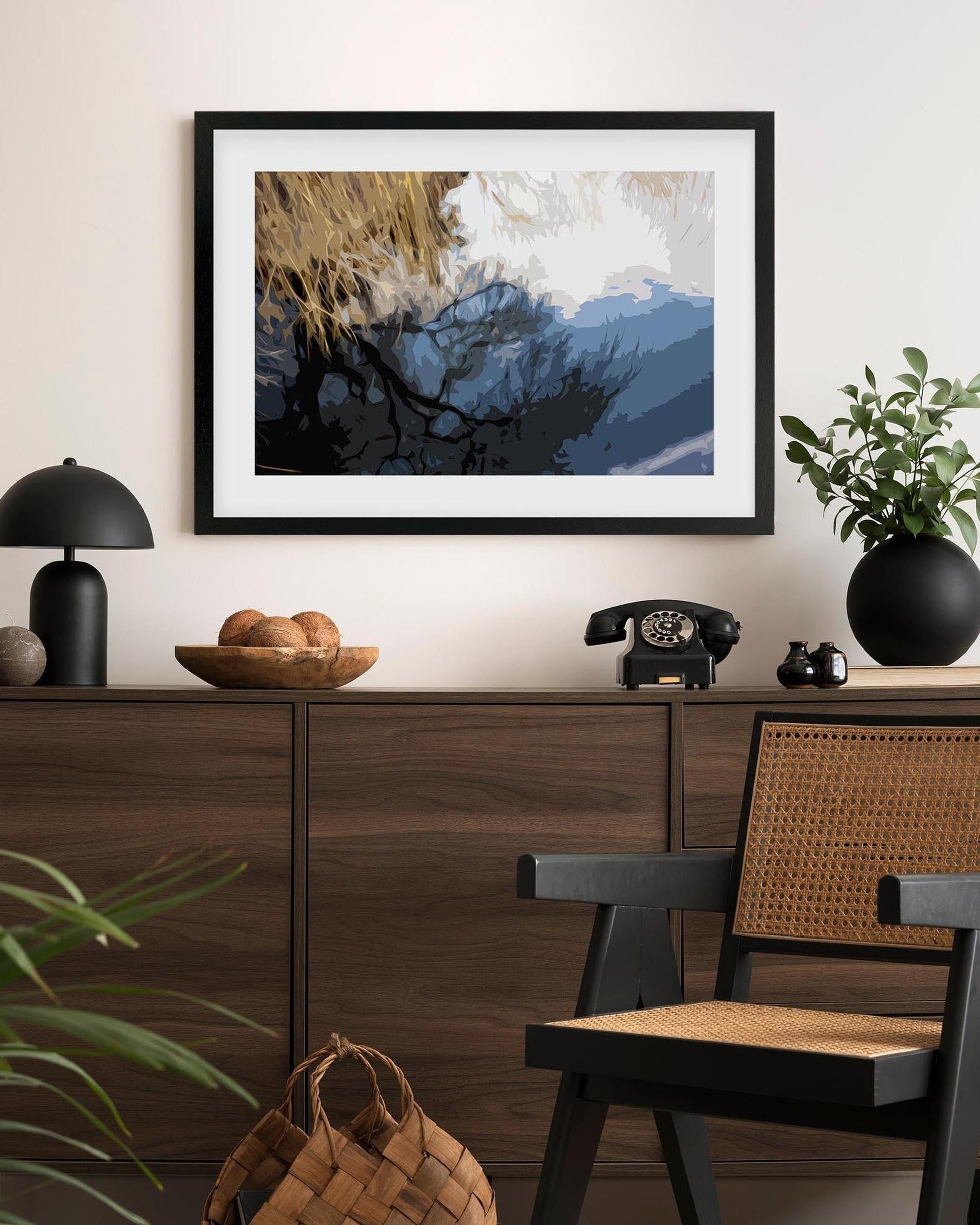 Framed abstract artwork on a wall above a wooden console table with decorative items.