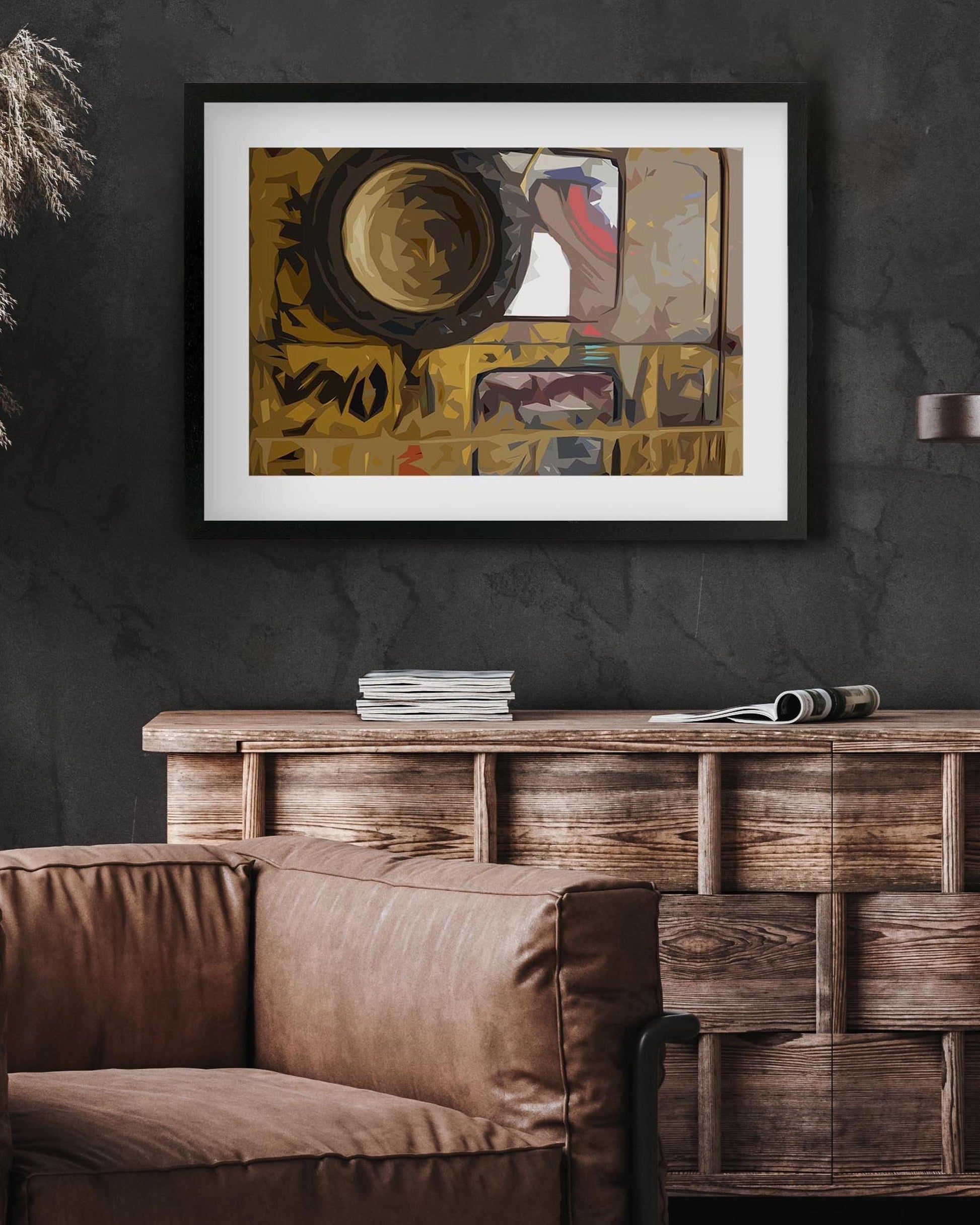 Framed abstract art piece on a dark wall above a wooden console table with a brown sofa.
