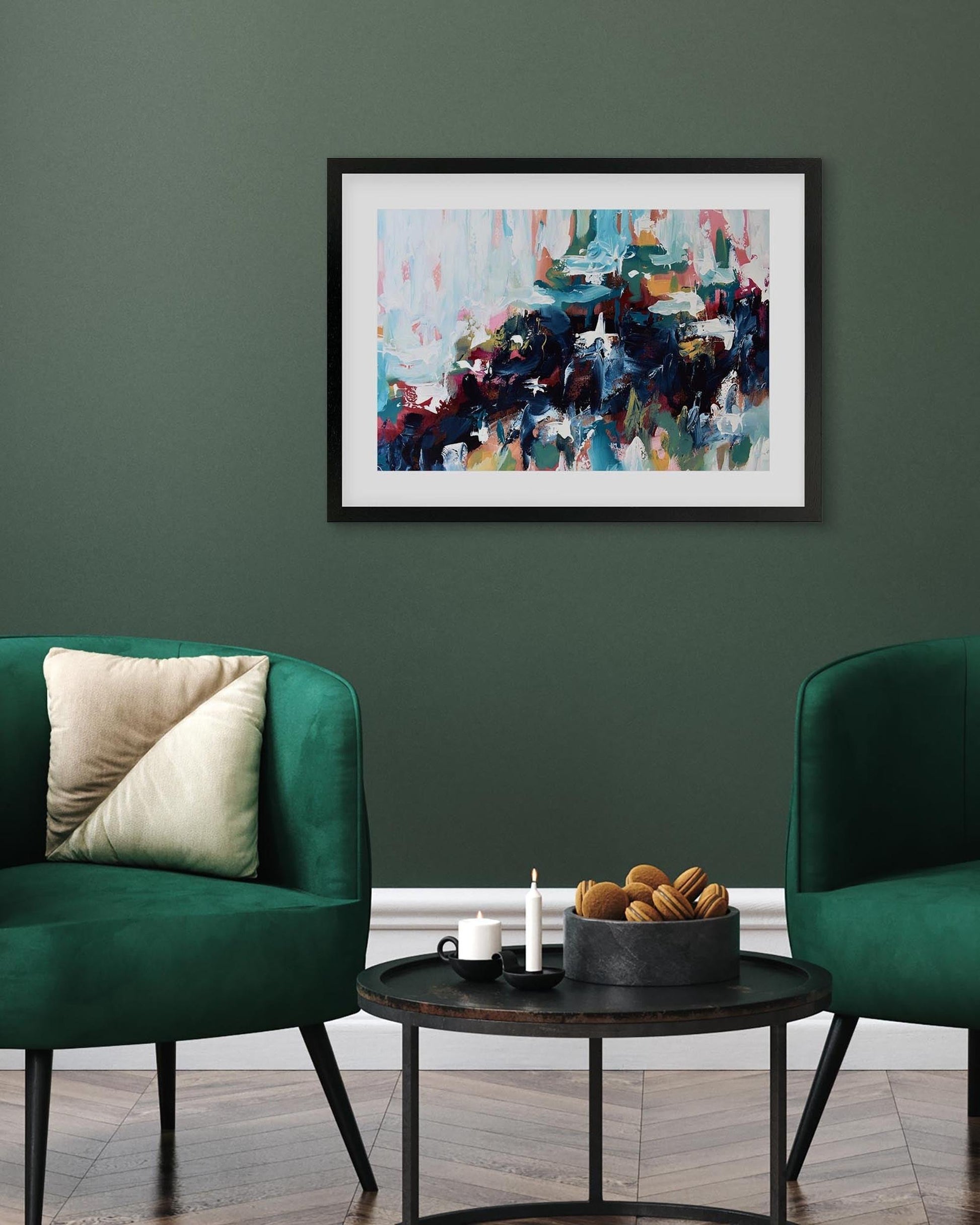 Abstract art piece on a green wall above a coffee table with decorative items.