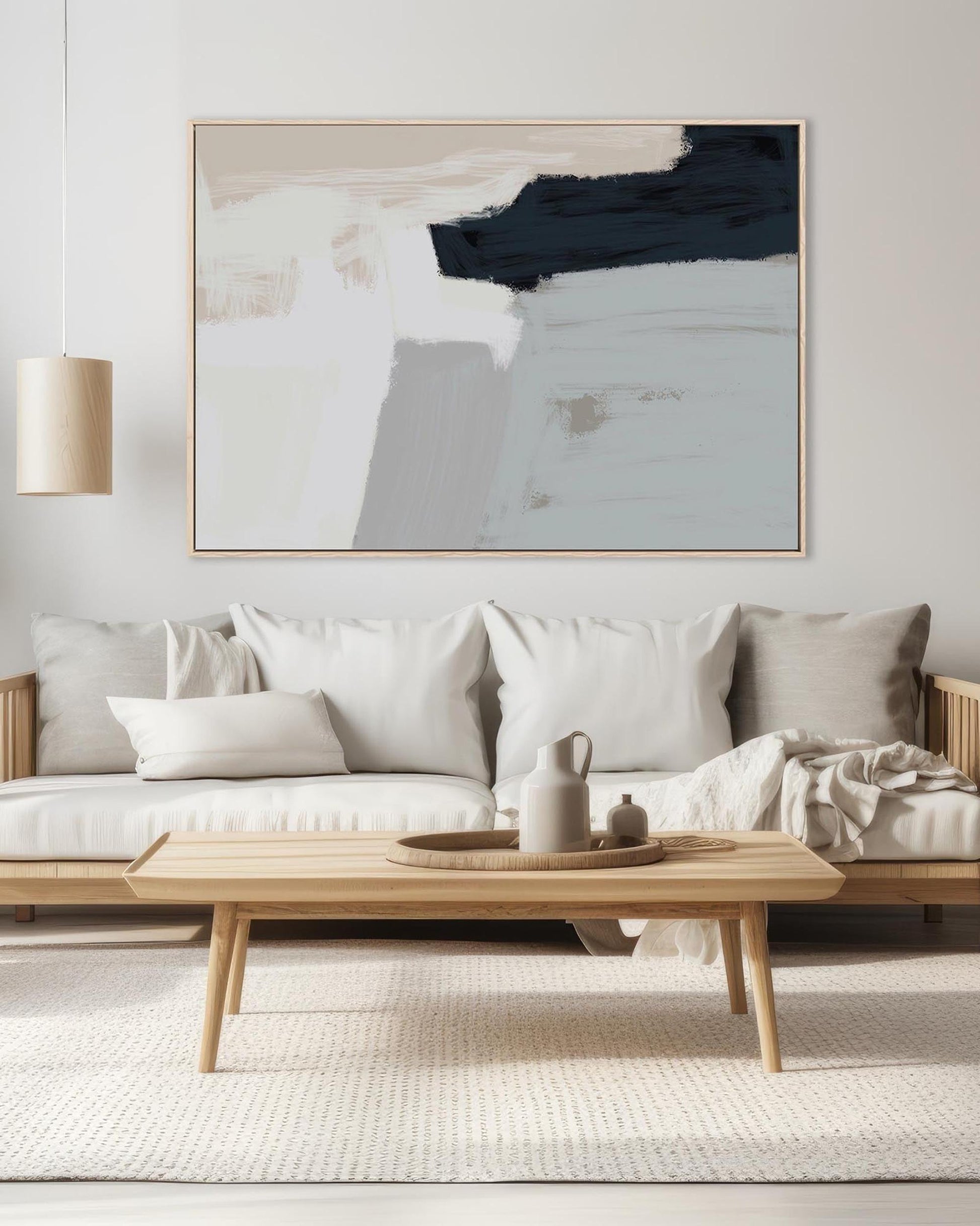 Modern living room with a neutral color palette, featuring a sofa, coffee table, and abstract art on the wall.