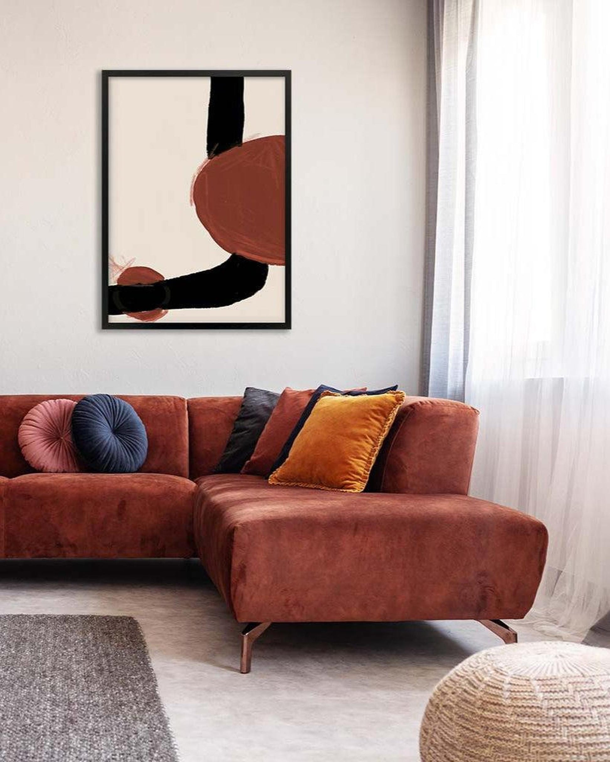 Modern living room with a brown sectional sofa and abstract art on the wall.