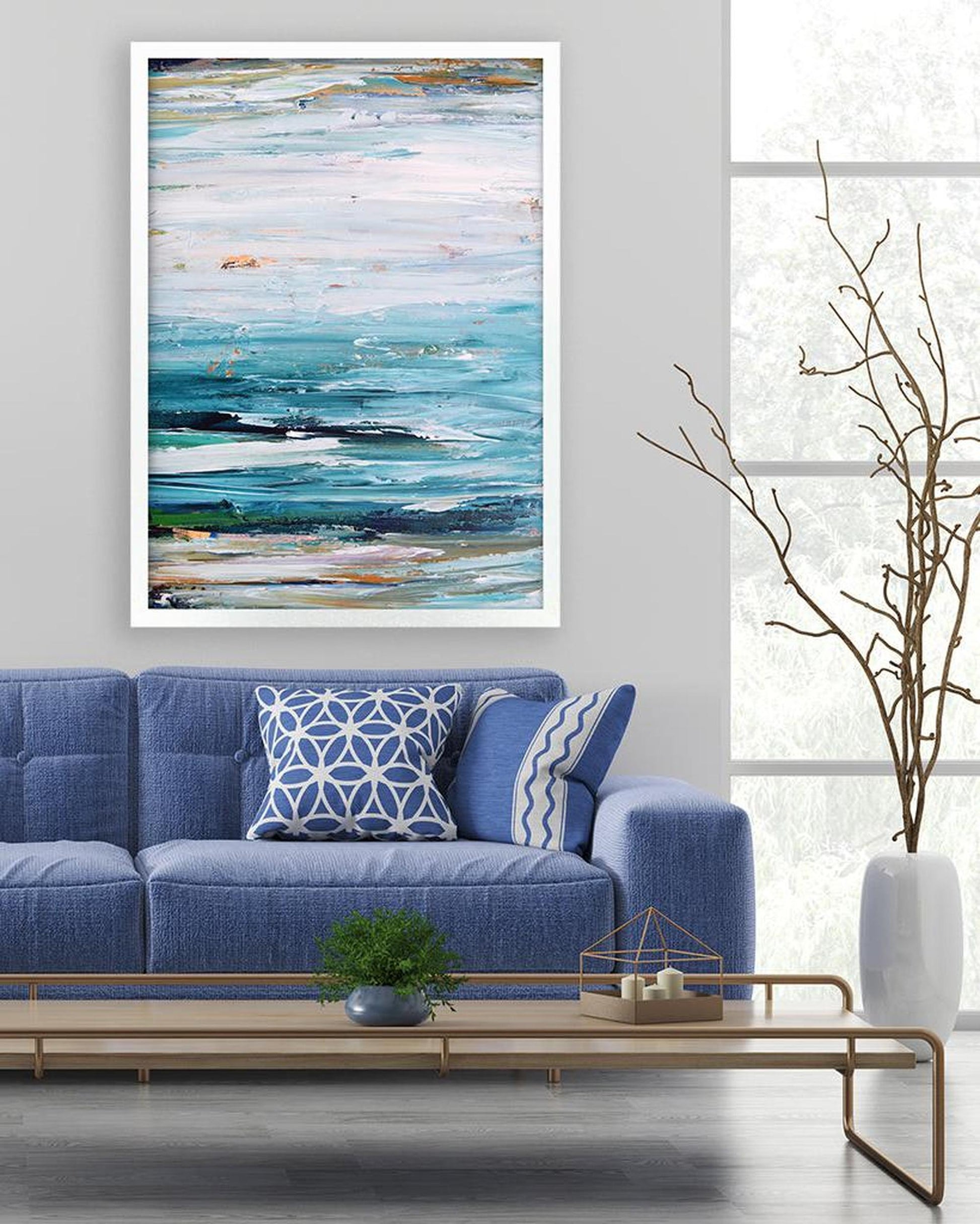 Living room with a blue sofa, abstract art on the wall, and a plant.