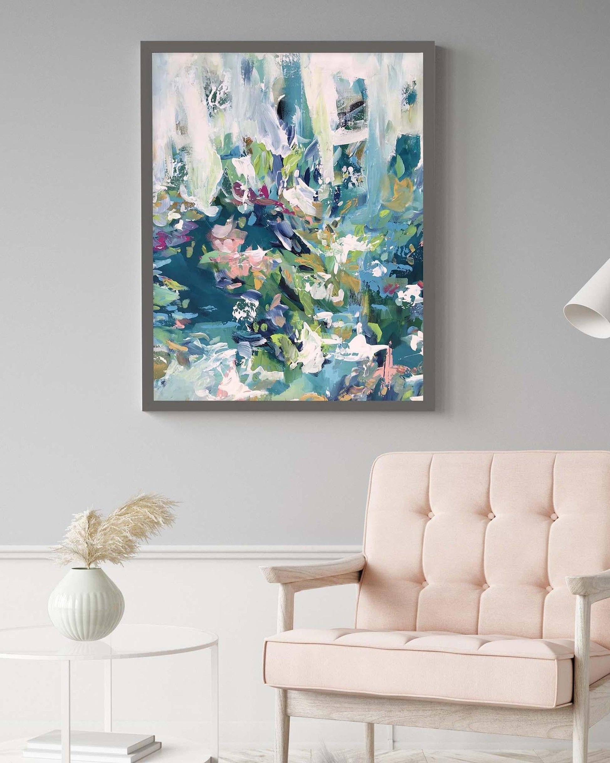 Abstract art print on a wall above a beige sofa in a living room.