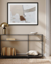Abstract art piece on a wall above a black metal console table with decorative items.