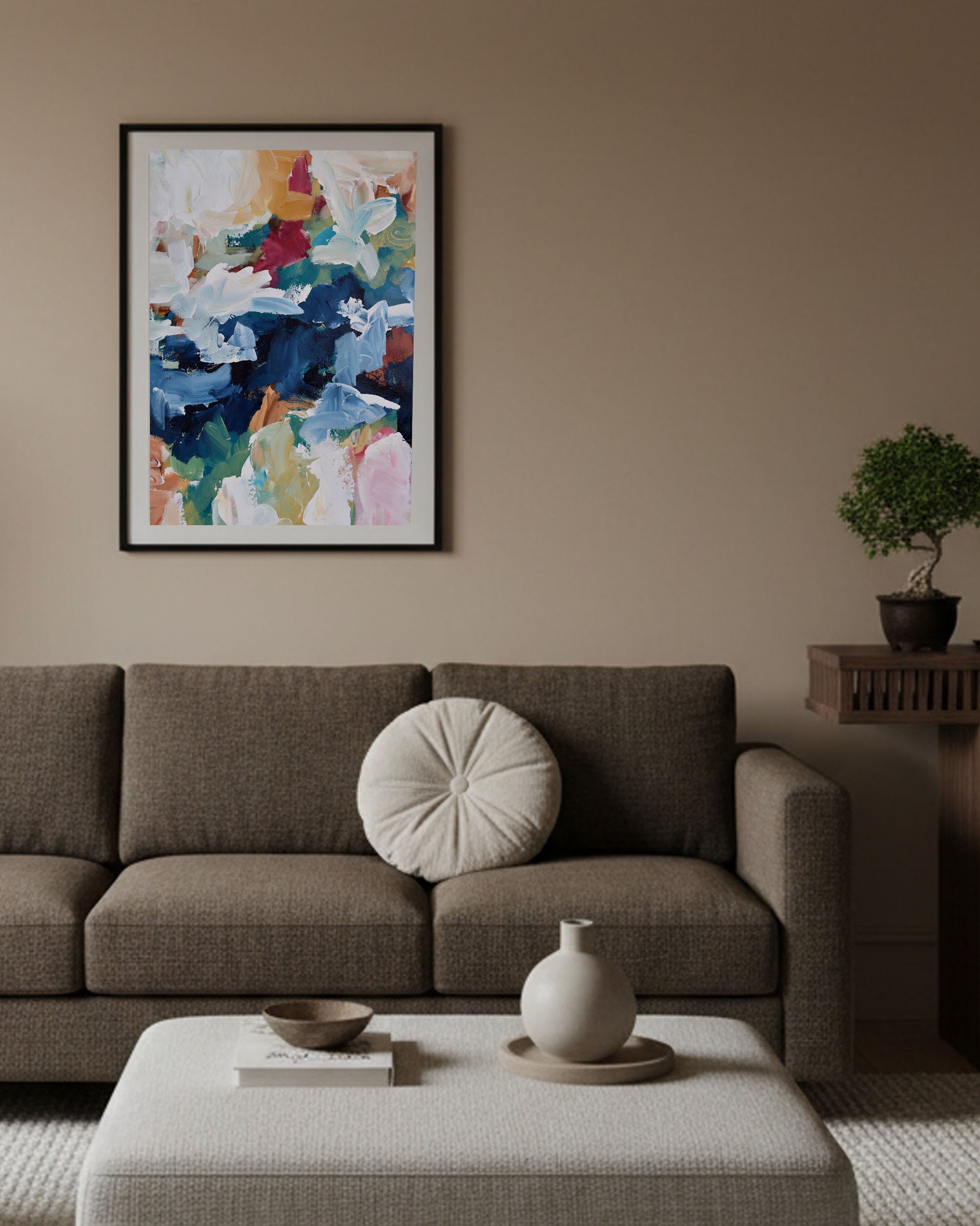 Living room with a brown sofa, abstract art on the wall, and decorative items.