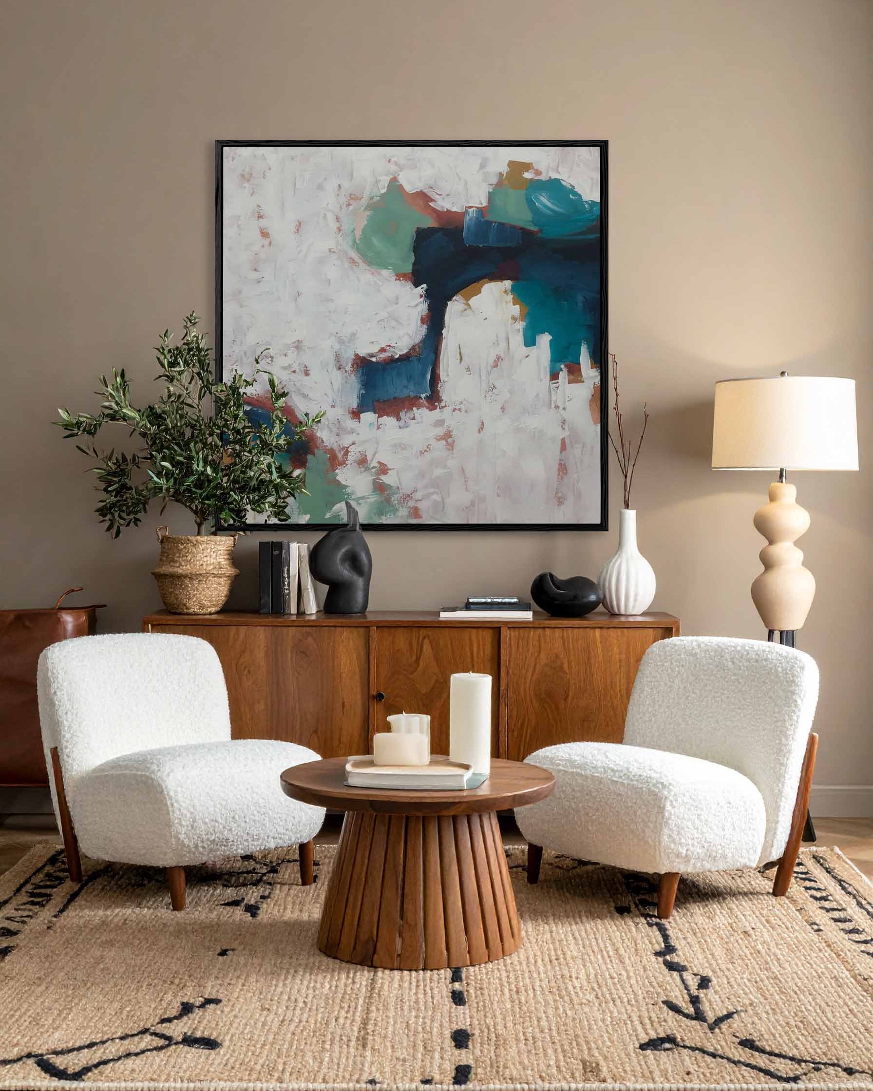 Living room with two white armchairs, a wooden side table, and modern abstract expressionist art on the wall.