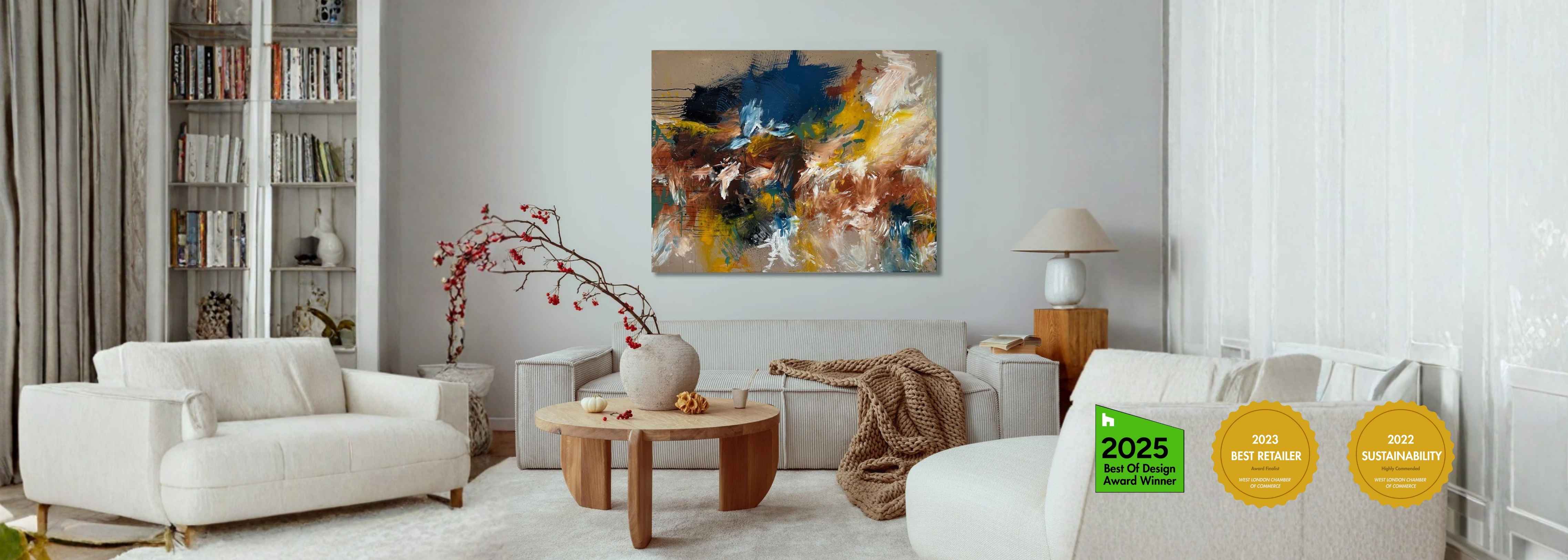 Modern living room with beige designer sofa, natural wood coffee table, and large original abstract painting on a white wall.