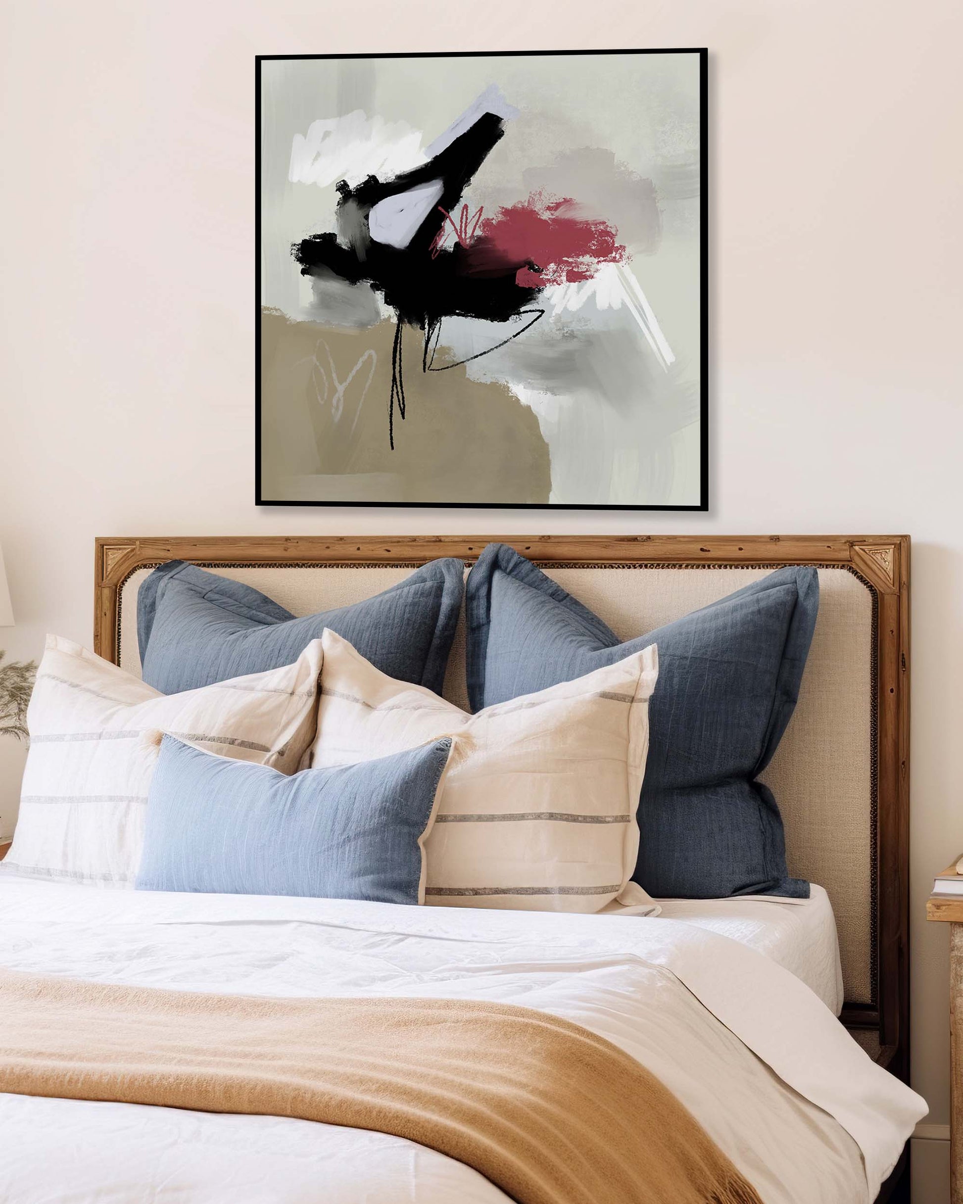 Bed with decorative pillows and a colorful abstract painting above the headboard.