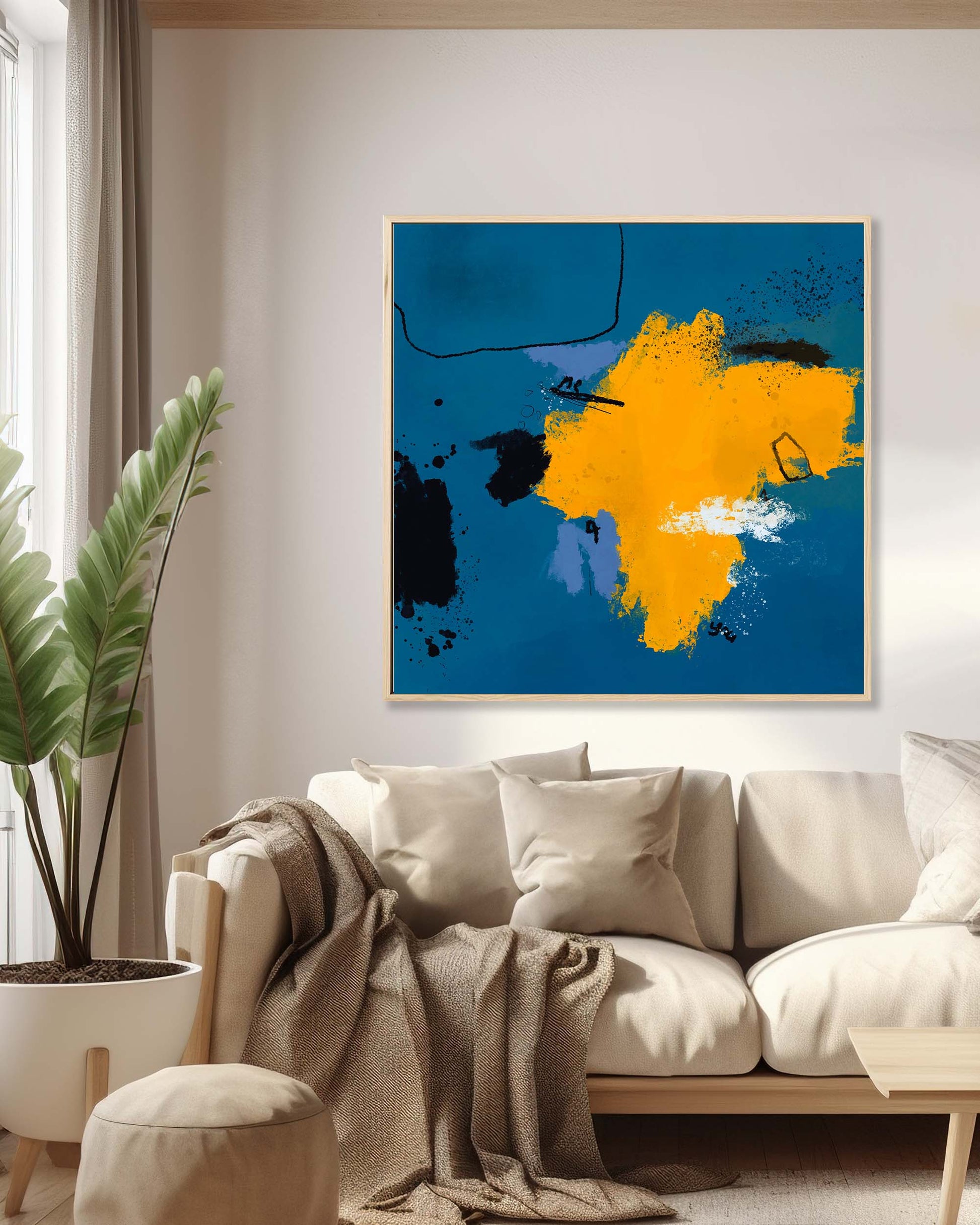 Framed canvas wall art featuring an abstract design with blue and orange colors, displayed above a sofa in a living room setting.