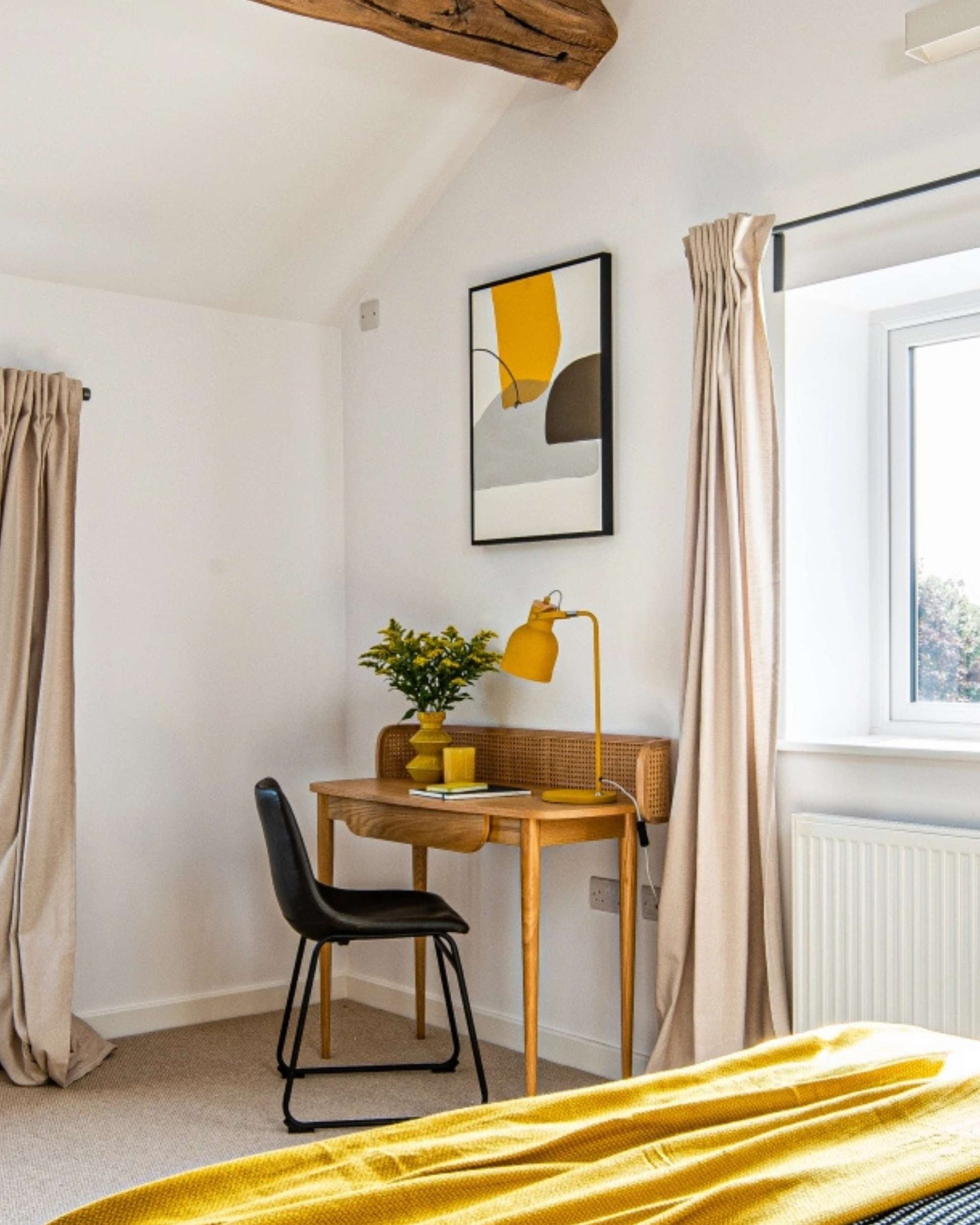 Small home office with a desk, chair, and abstract art on the wall.