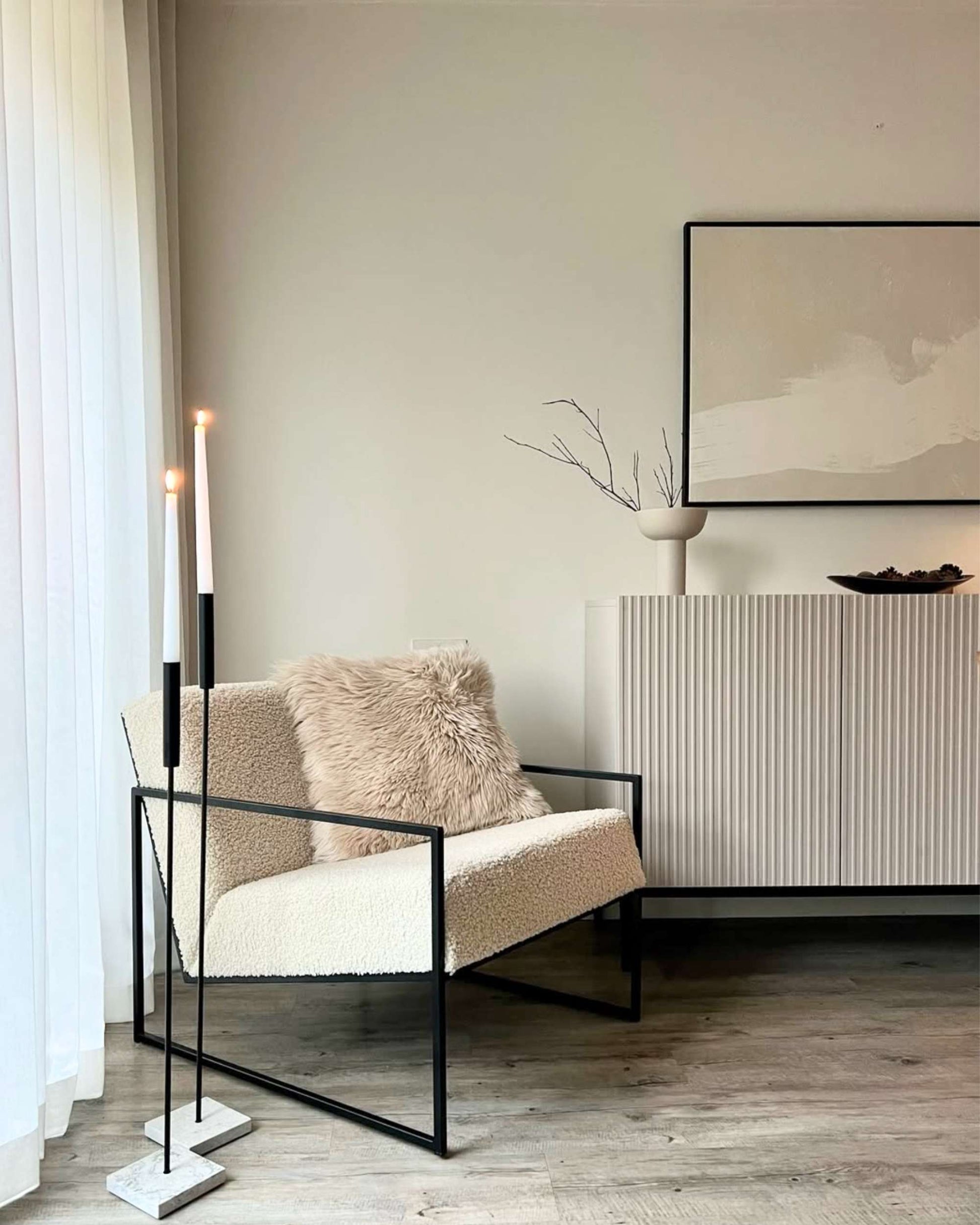 Modern living room with a chair, cushion, and decorative items.