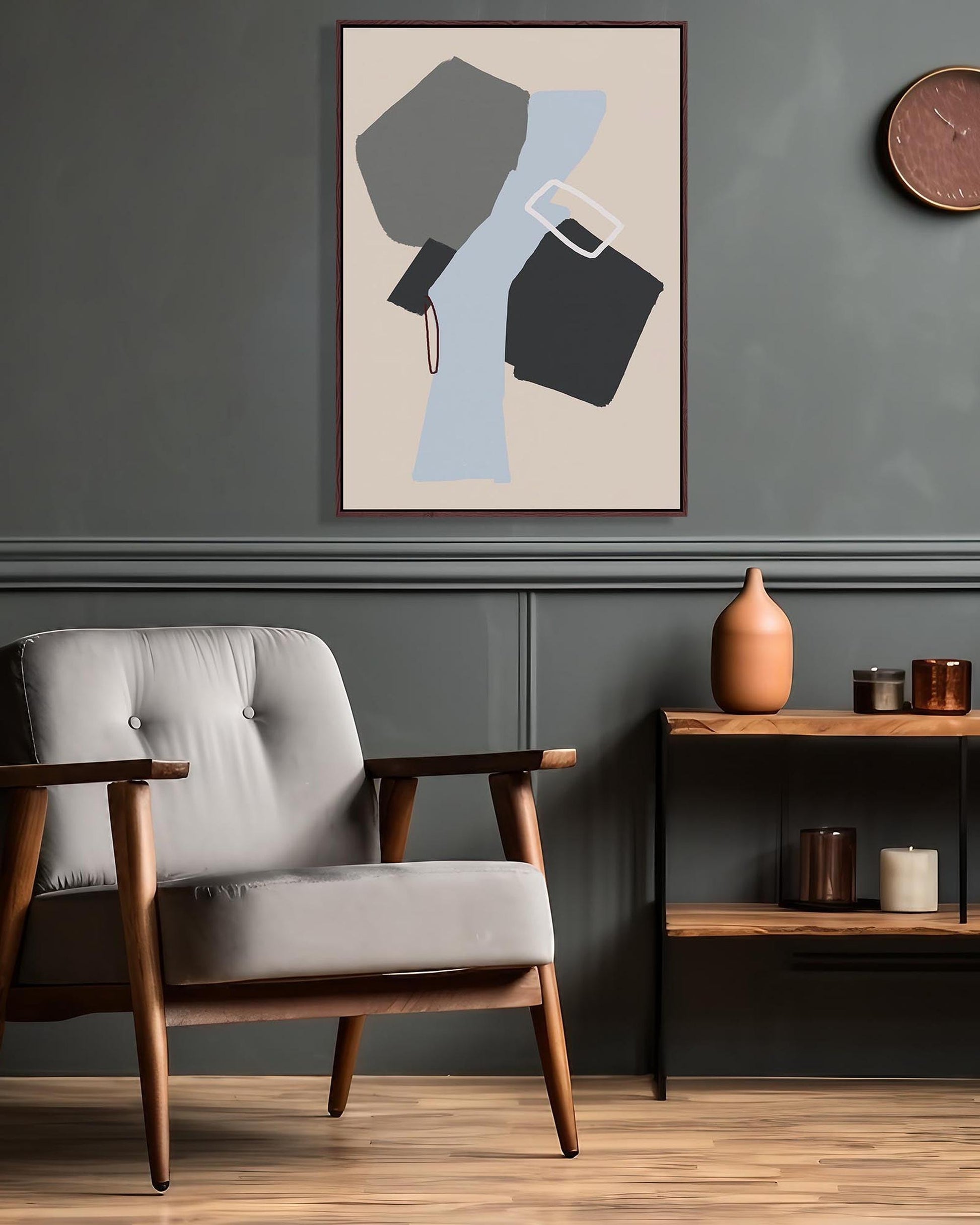 Modern living room with a gray armchair, abstract art, and wooden shelf.